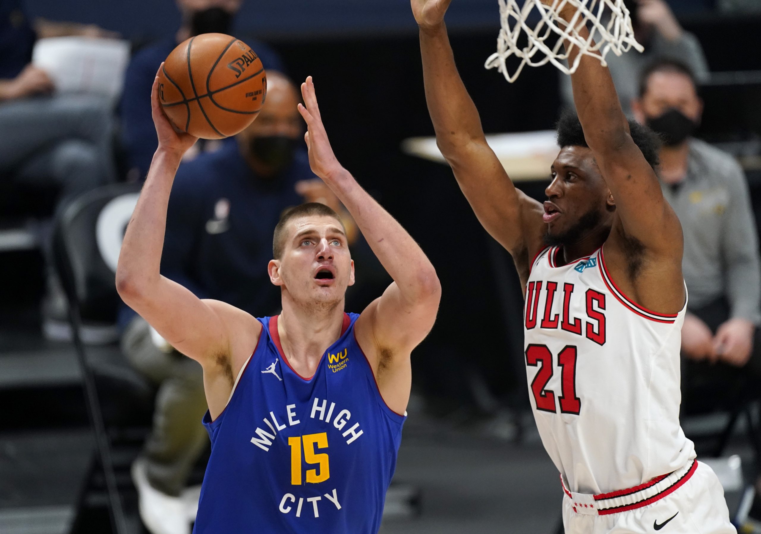 Denver Nuggets center Nikola Jokic, left, drives to the basket as Chicago Bulls forward Thaddeus Young defends in the second half of an NBA basketball game Friday, March 19, 2021, in Denver. (AP Photo/David Zalubowski)
