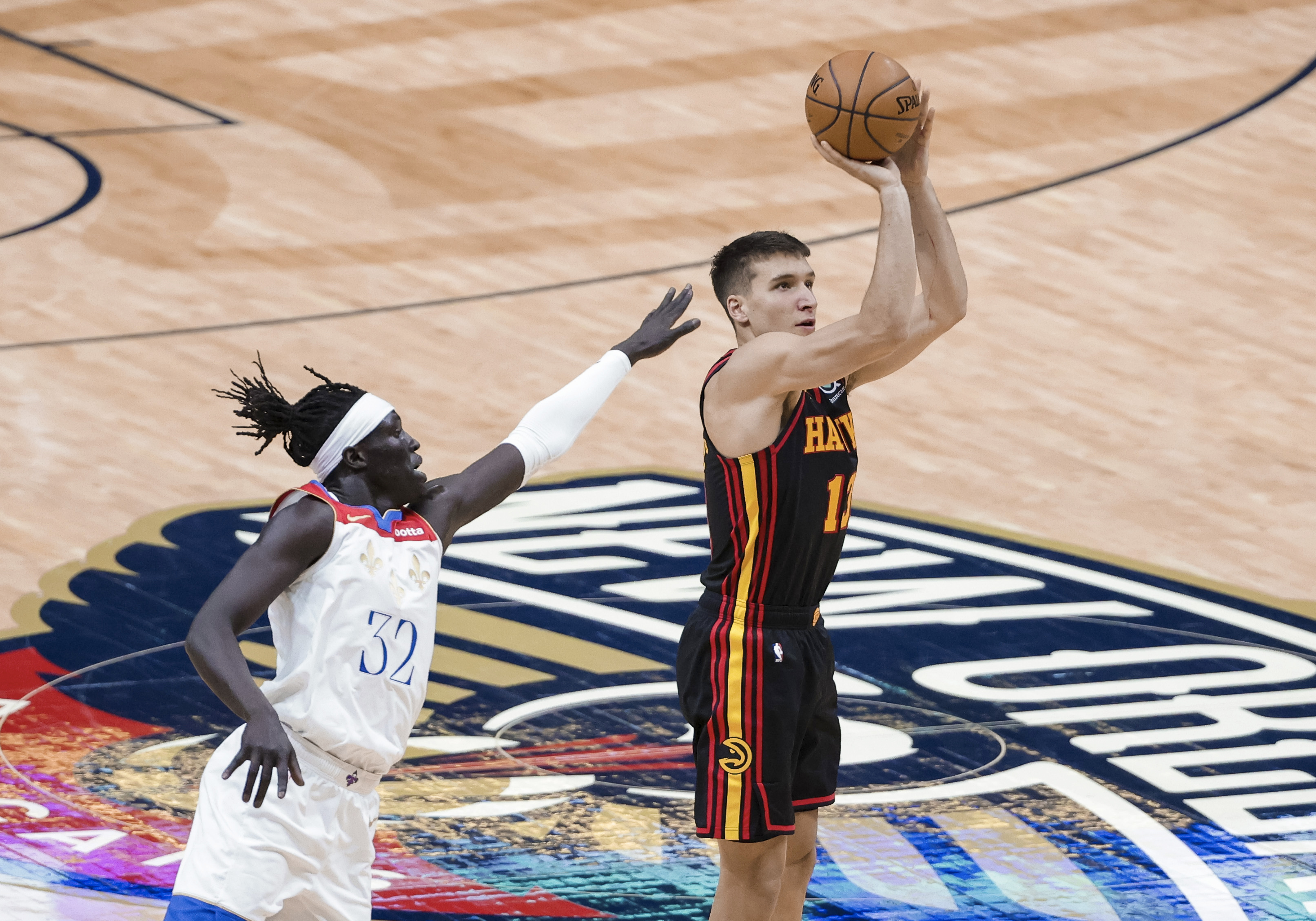 Atlanta Hawks guard Bogdan Bogdanovic (13) shoots a three-point basket past New Orleans Pelicans forward Wenyen Gabriel (32) in the second quarter of an NBA basketball game in New Orleans, Friday, April 2, 2021. (AP Photo/Derick Hingle)