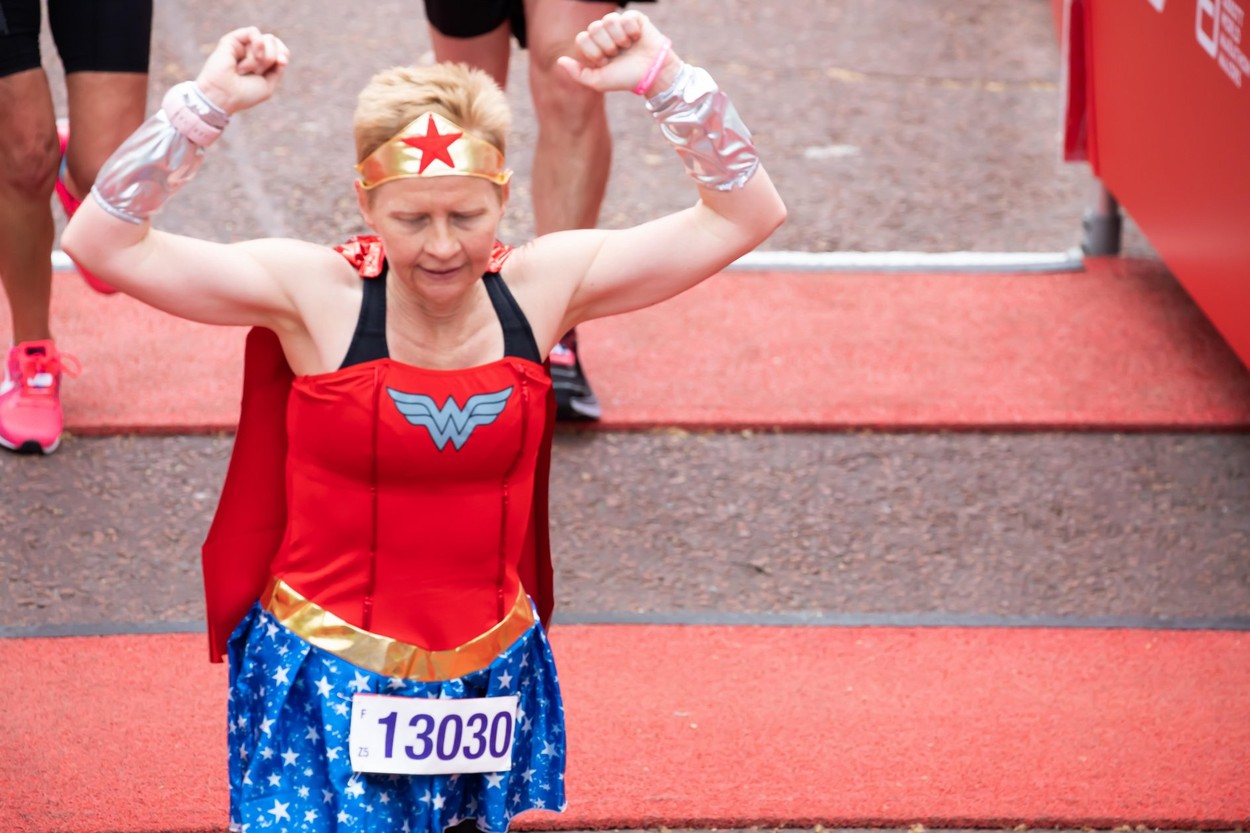London, UK. 28th April 2019. Jackie Dockerill finishes The 39th London Marathon dressed as Wonderwoman. Credit: Keith Larby/Alamy Live News