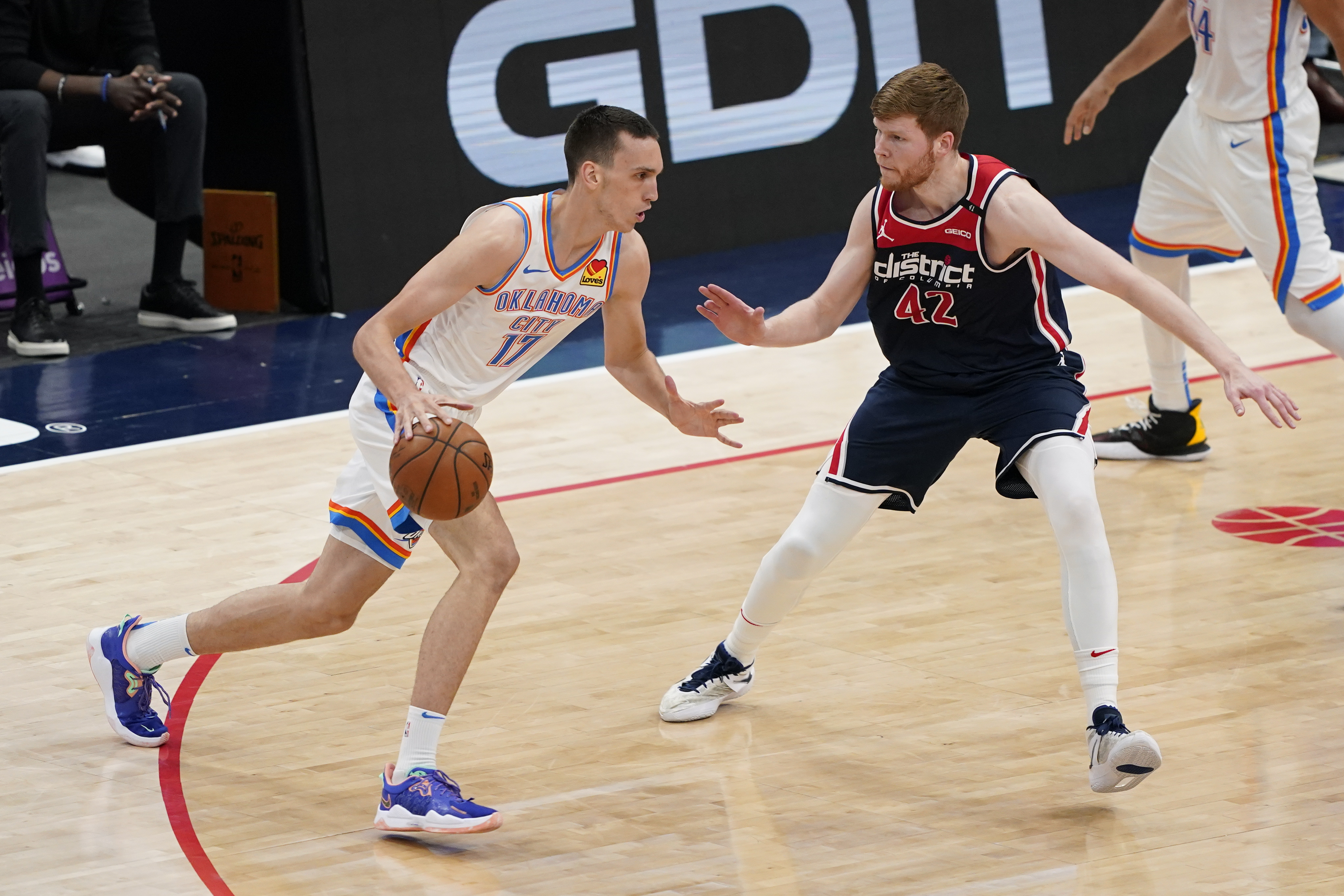 Oklahoma City Thunder forward Aleksej Pokusevski, left, drives against Washington Wizards forward Davis Bertans in the first half of an NBA basketball game, Monday, April 19, 2021, in Washington. (AP Photo/Patrick Semansky)