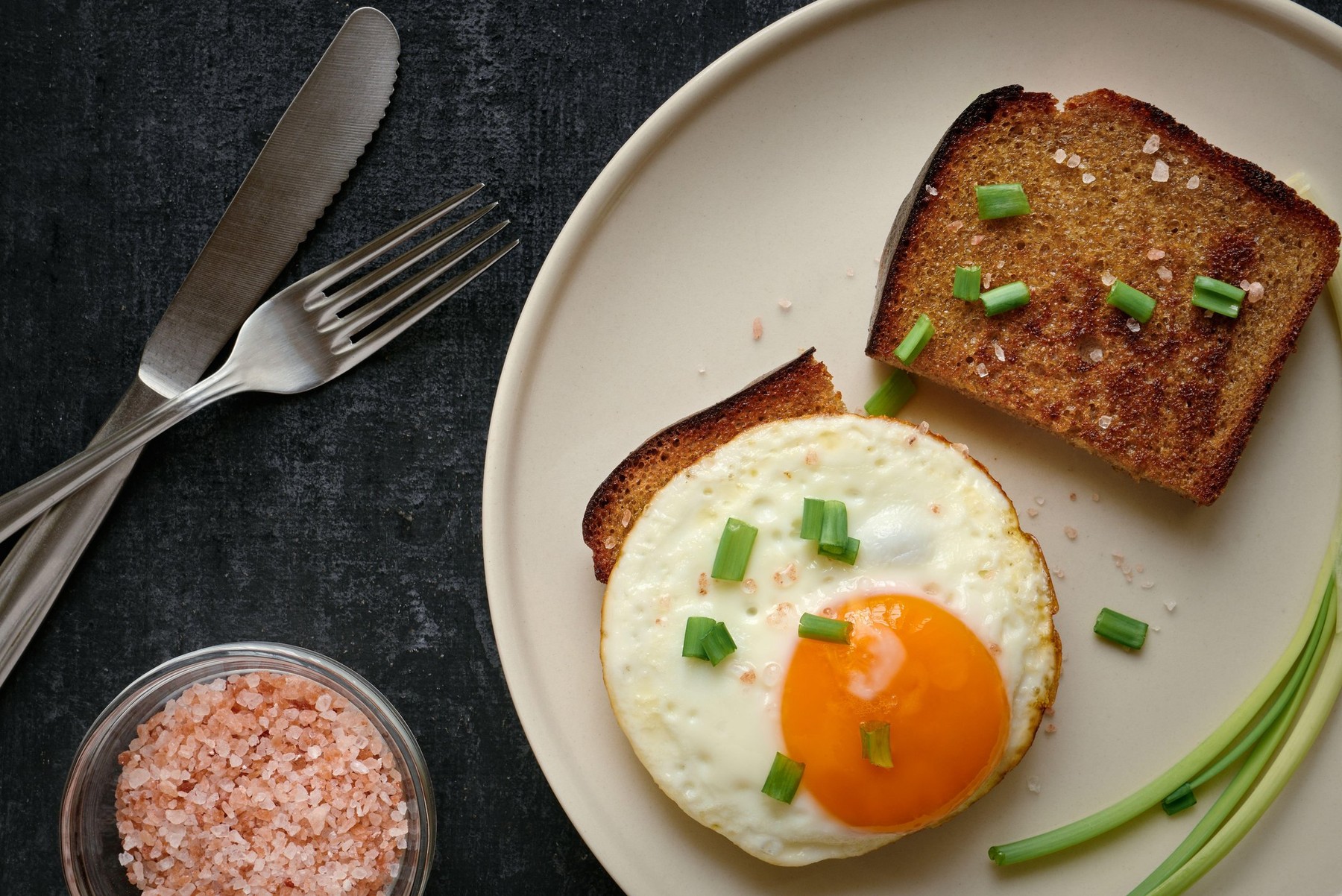 Fried egg and rye fried bread slices close up