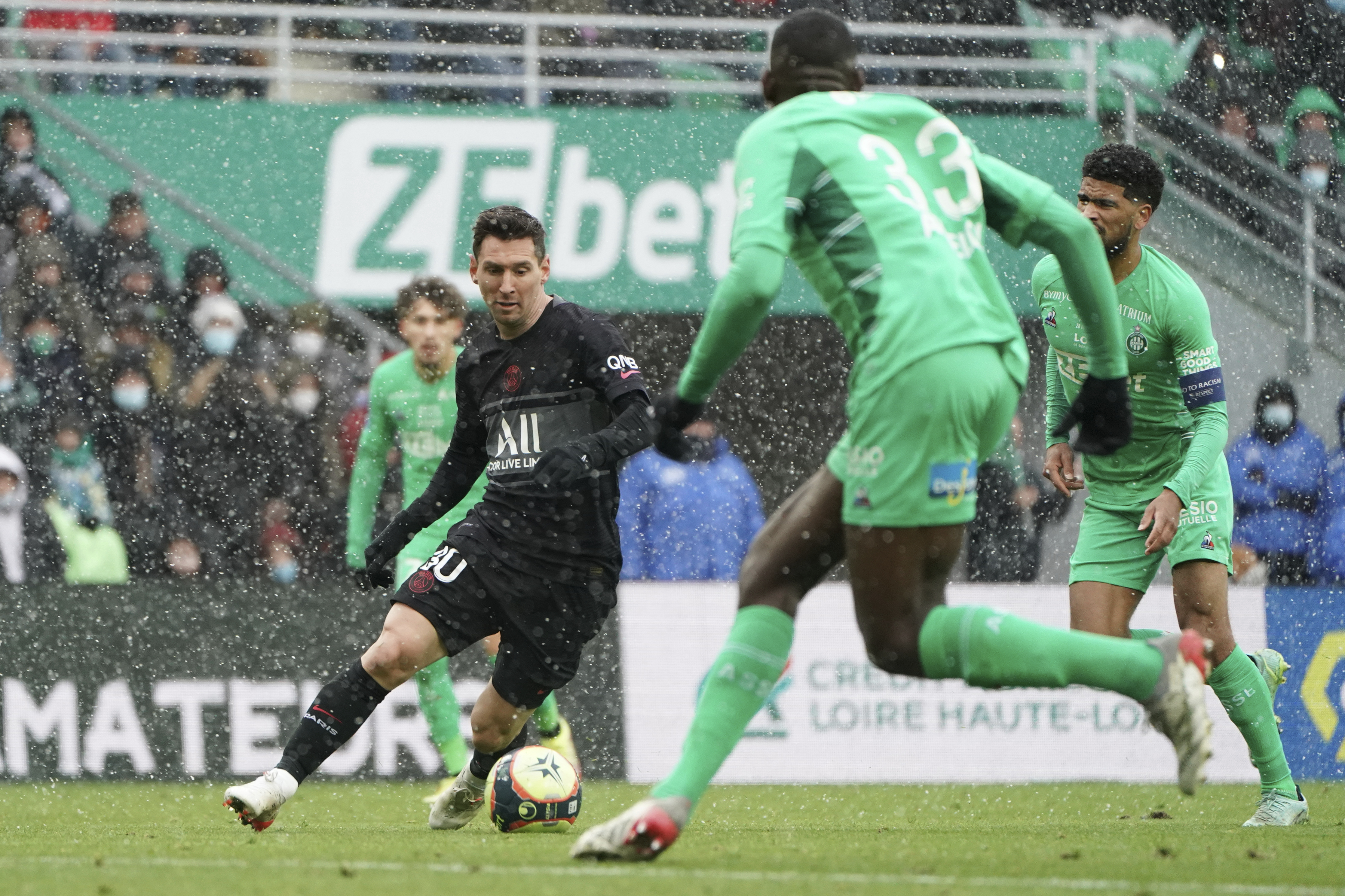 PSG's Lionel Messi, left, challenges for the ball with Saint-Etienne' players during the French League One soccer between Saint-Etienne and Paris Saint Germain, in Saint-Etienne, central France, Sunday, Nov. 28, 2021. (AP Photo/Laurent Cipriani)