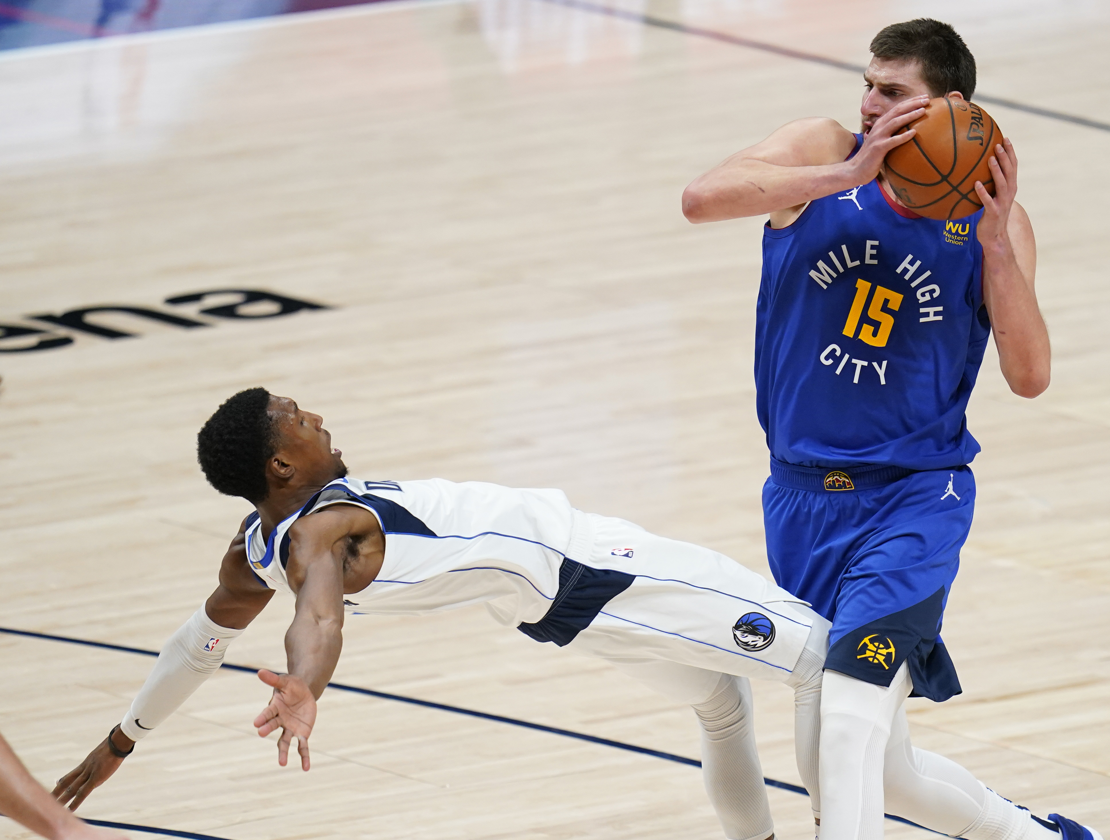 Denver Nuggets center Nikola Jokic (15) draws the foul from Dallas Mavericks guard Josh Richardson during overtime in an NBA basketball game Thursday, Jan. 7, 2021, in Denver. The Mavericks won 124-117. (AP Photo/Jack Dempsey)