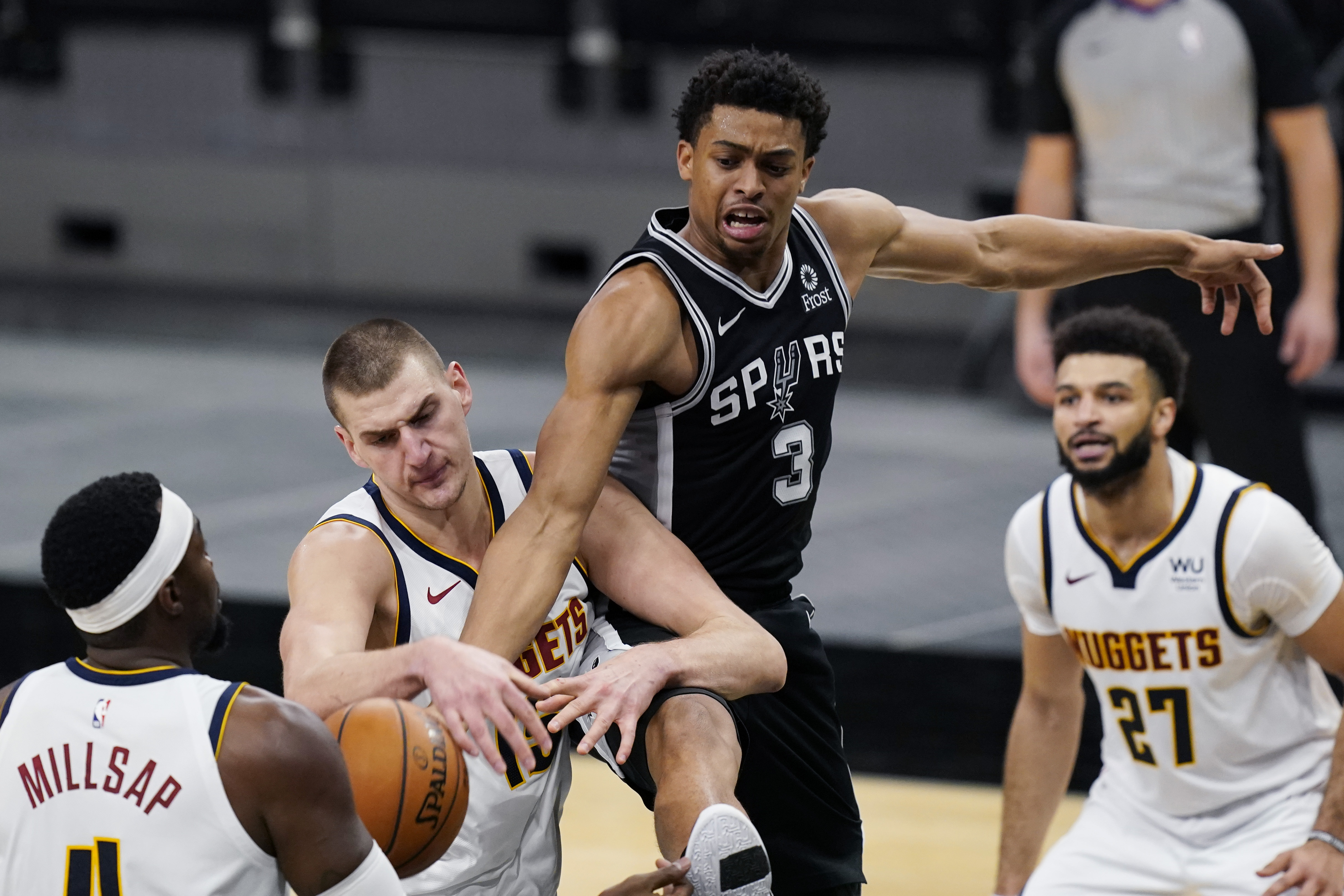 Denver Nuggets center Nikola Jokic (15) and San Antonio Spurs forward Keldon Johnson (3) vie for control of a rebound during the first half of an NBA basketball game in San Antonio, Friday, Jan. 29, 2021. (AP Photo/Eric Gay)