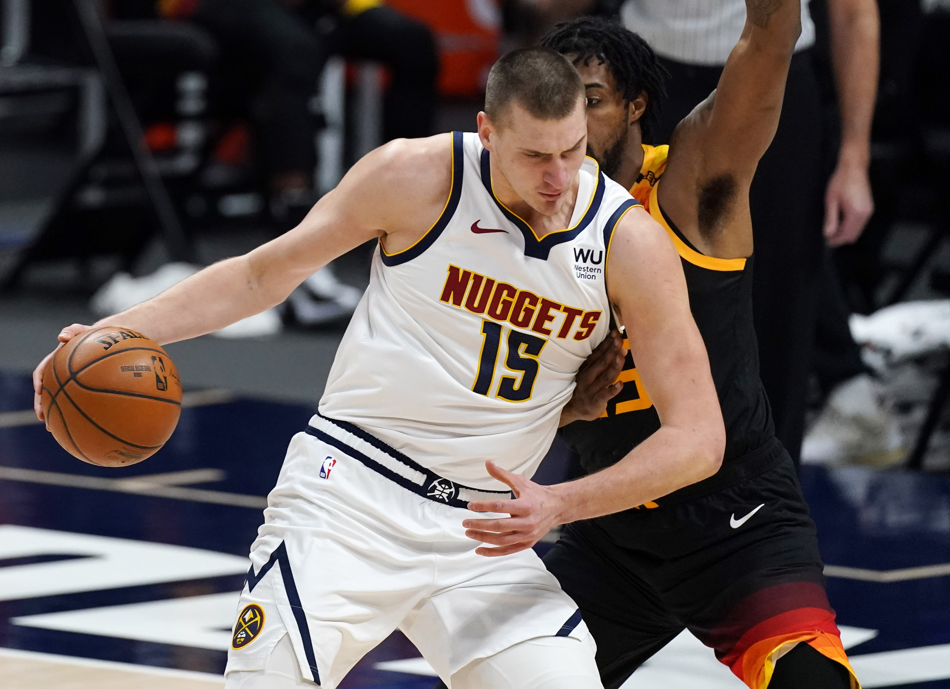 Denver Nuggets center Nikola Jokic, front, drives the lane as Utah Jazz center Derrick Favors defends in the first half of an NBA basketball game Sunday, Jan. 31, 2021, in Denver. (AP Photo/David Zalubowski)