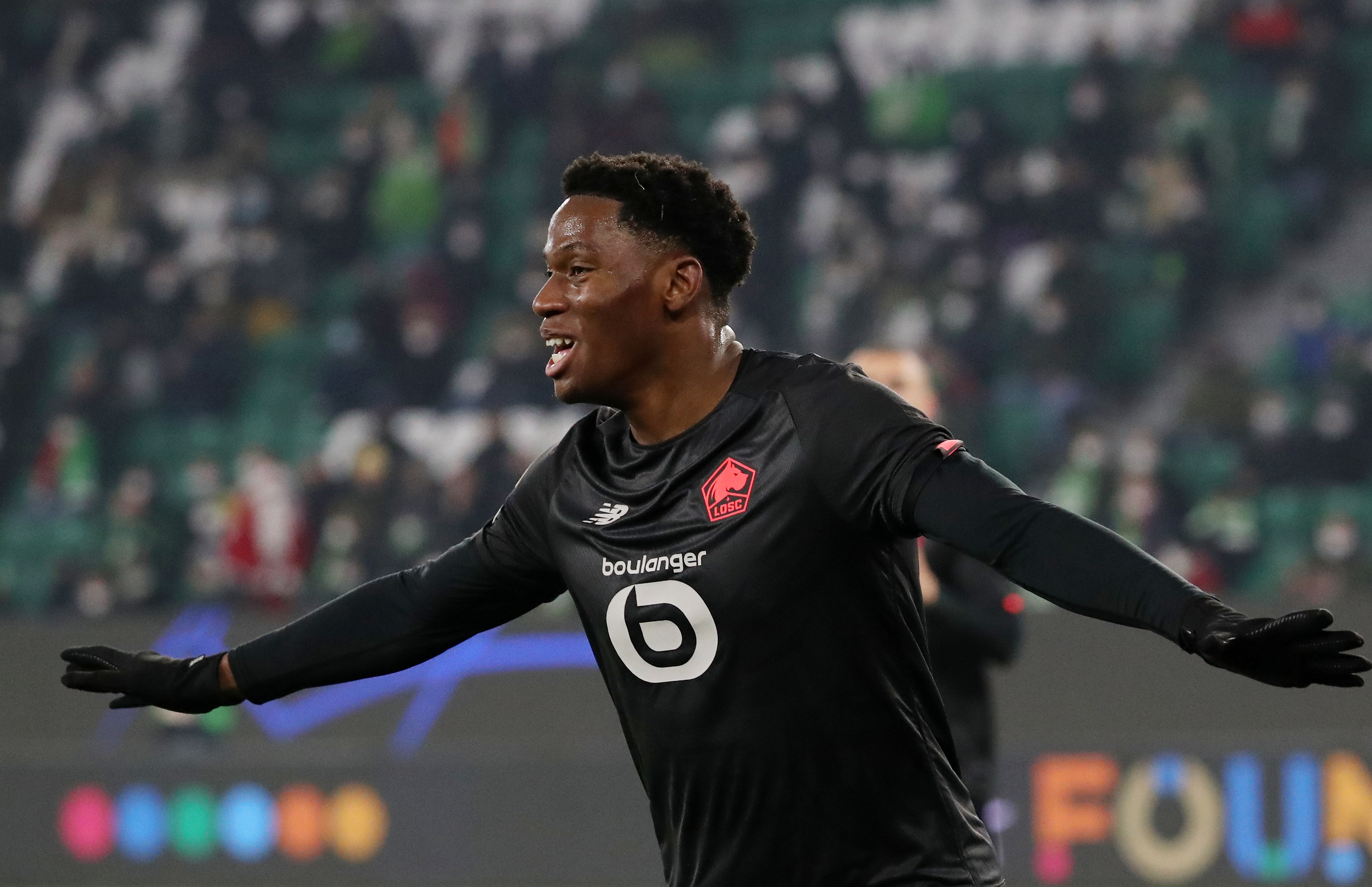 epa09630513 Lille's Jonathan David celebrates after scoring the 2-0 lead during the UEFA Champions League group G soccer match between VfL Wolfsburg and Lille OSC (LOSC) in Wolfsburg, Germany, 08 December 2021.  EPA-EFE/Focke Strangmann