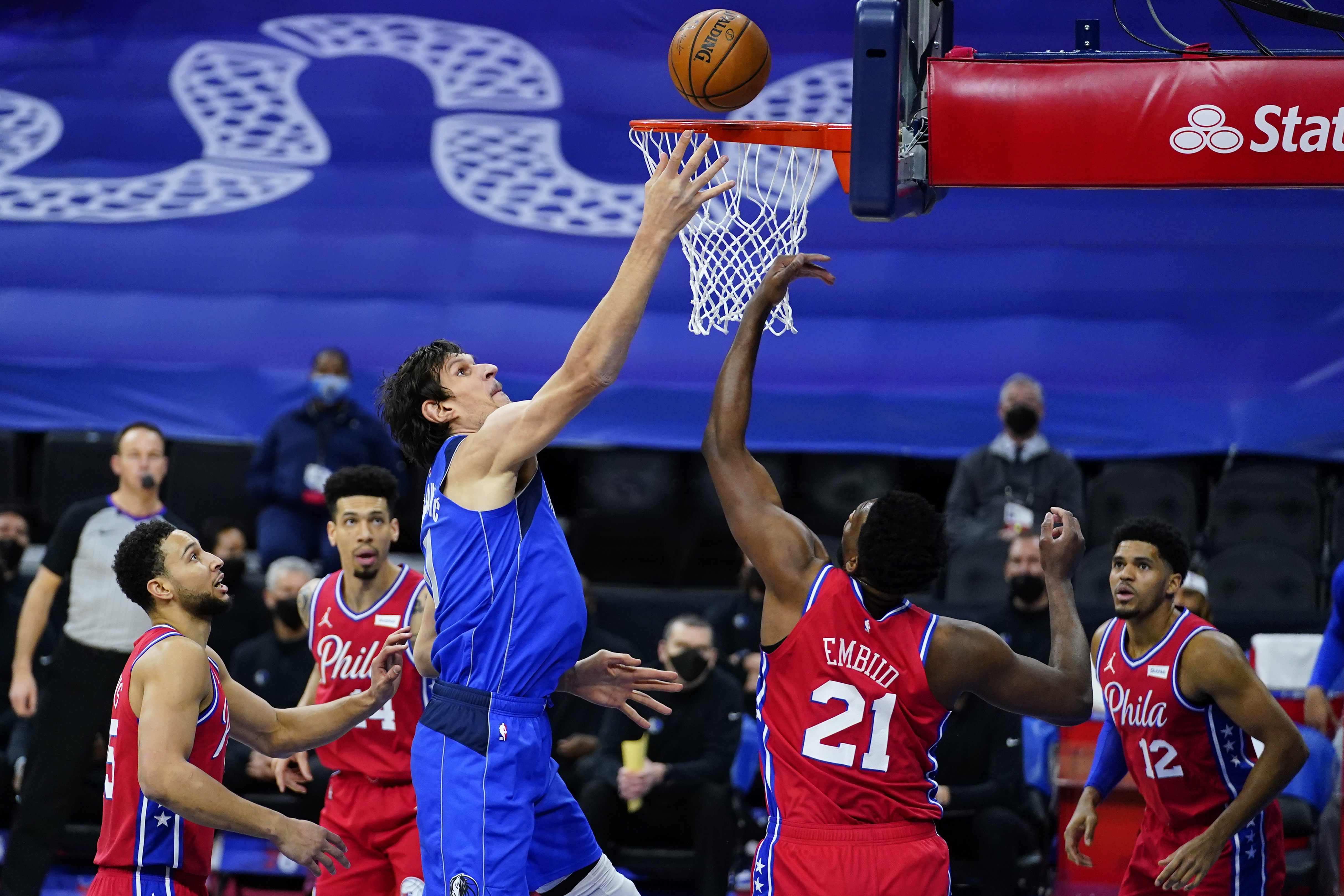 Dallas Mavericks' Boban Marjanovic, left, goes up for a shot against Philadelphia 76ers' Joel Embiid during the first half of an NBA basketball game, Thursday, Feb. 25, 2021, in Philadelphia. (AP Photo/Matt Slocum)