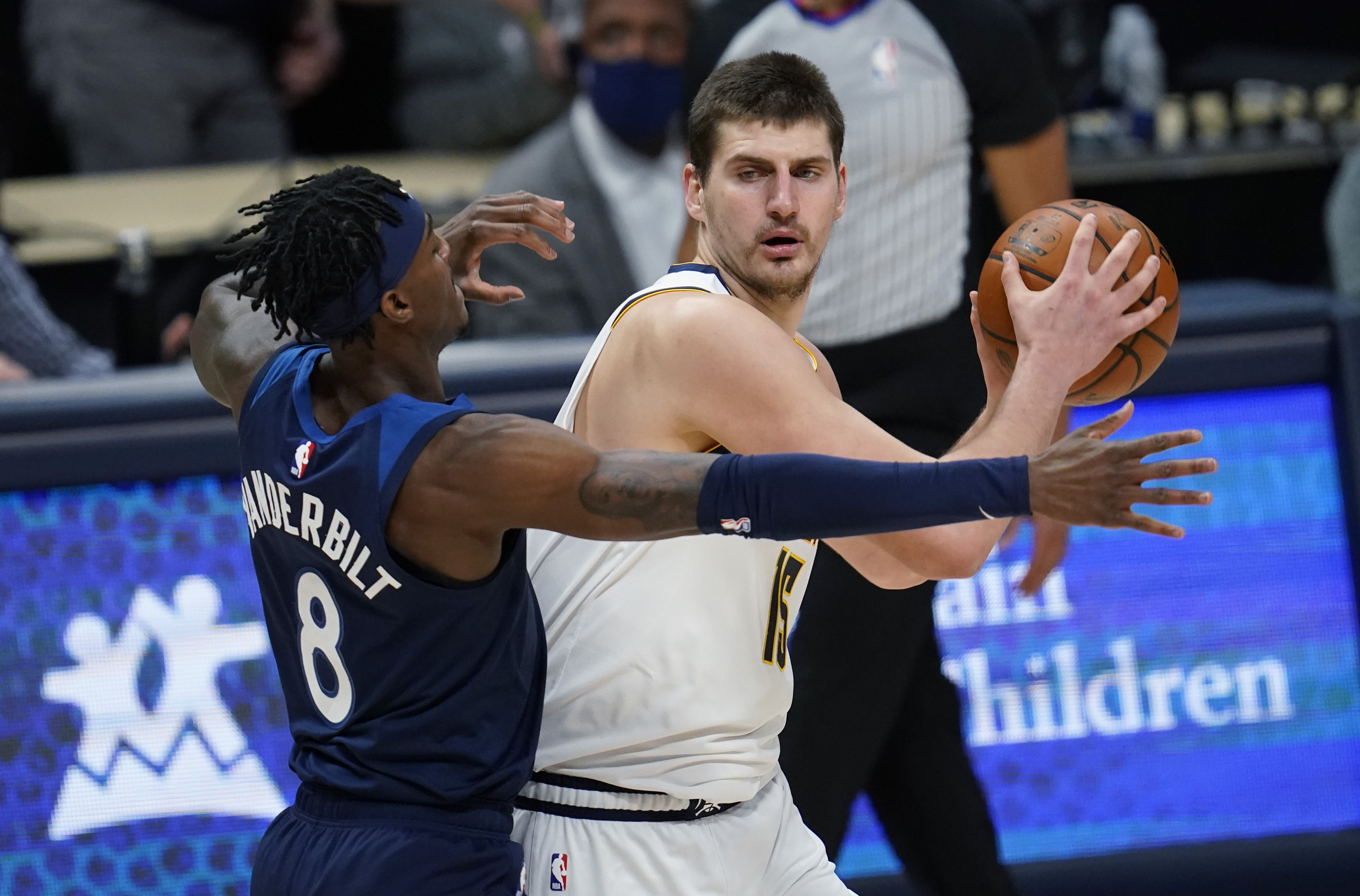 Denver Nuggets center Nikola Jokic, right, looks to pass the ball as Minnesota Timberwolves forward Jarred Vanderbilt defends during the first half of an NBA basketball game Tuesday, Jan. 5, 2021, in Denver. (AP Photo/David Zalubowski)