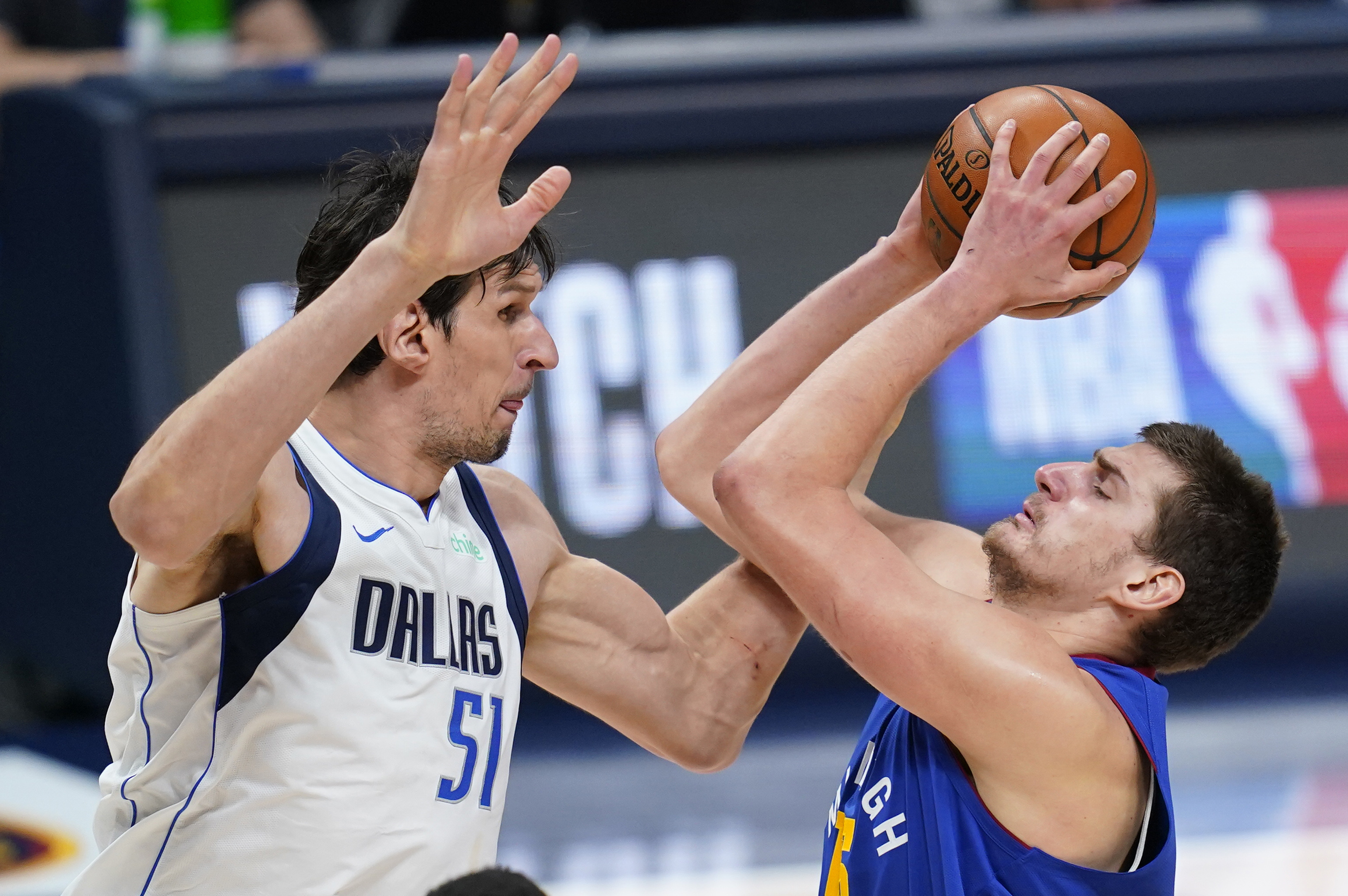 Denver Nuggets center Nikola Jokic (15) shoots next to Dallas Mavericks center Boban Marjanovic (51) during the third quarter of an NBA basketball game Thursday, Jan. 7, 2021, in Denver. (AP Photo/Jack Dempsey)