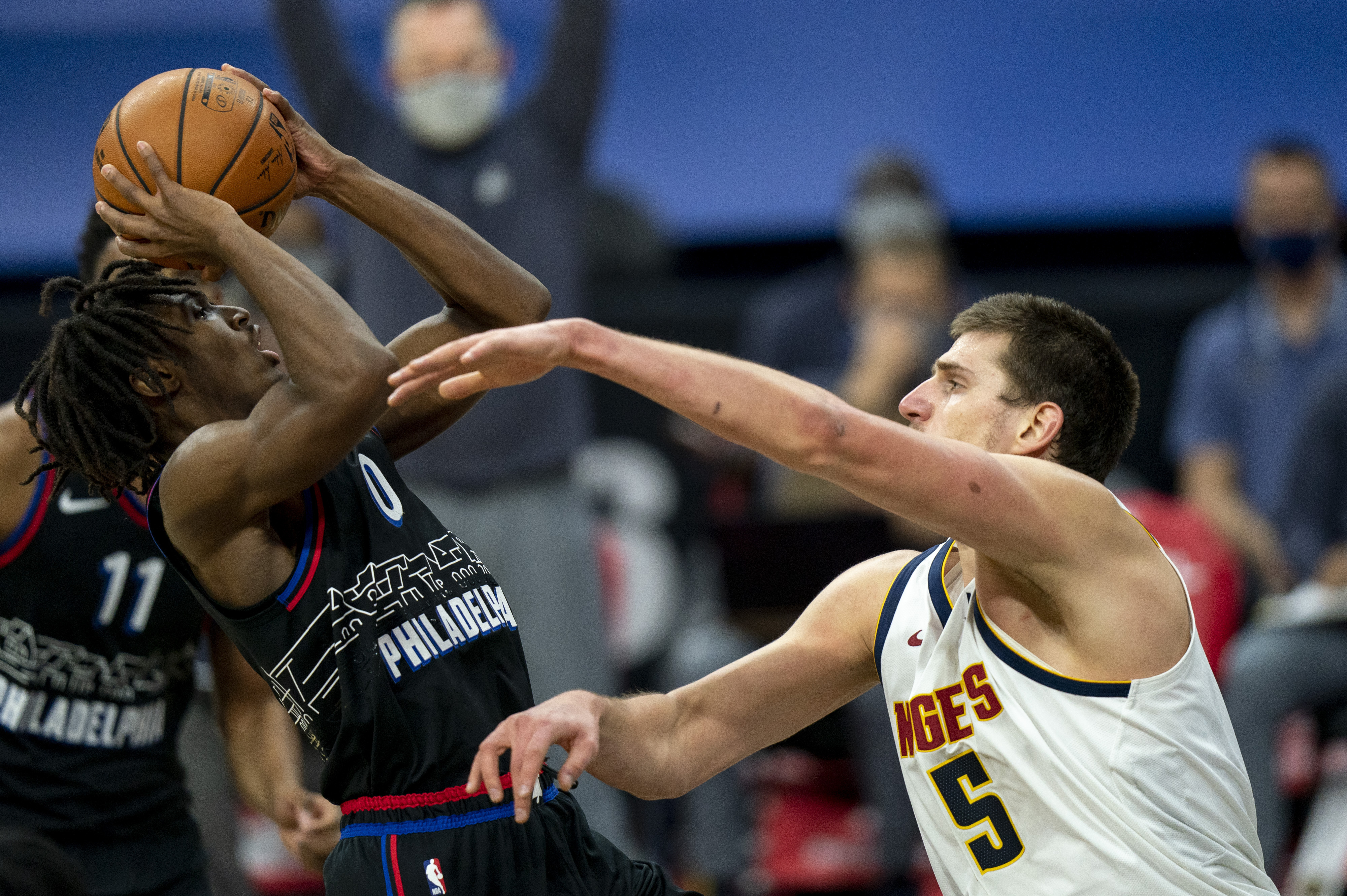 Philadelphia 76ers' Tyrese Maxey, left, shoots the ball against Denver Nuggets' Nikola Jokic, right, during the second half of an NBA basketball game, Saturday, Jan. 9, 2021, in Philadelphia. (AP Photo/Chris Szagola)