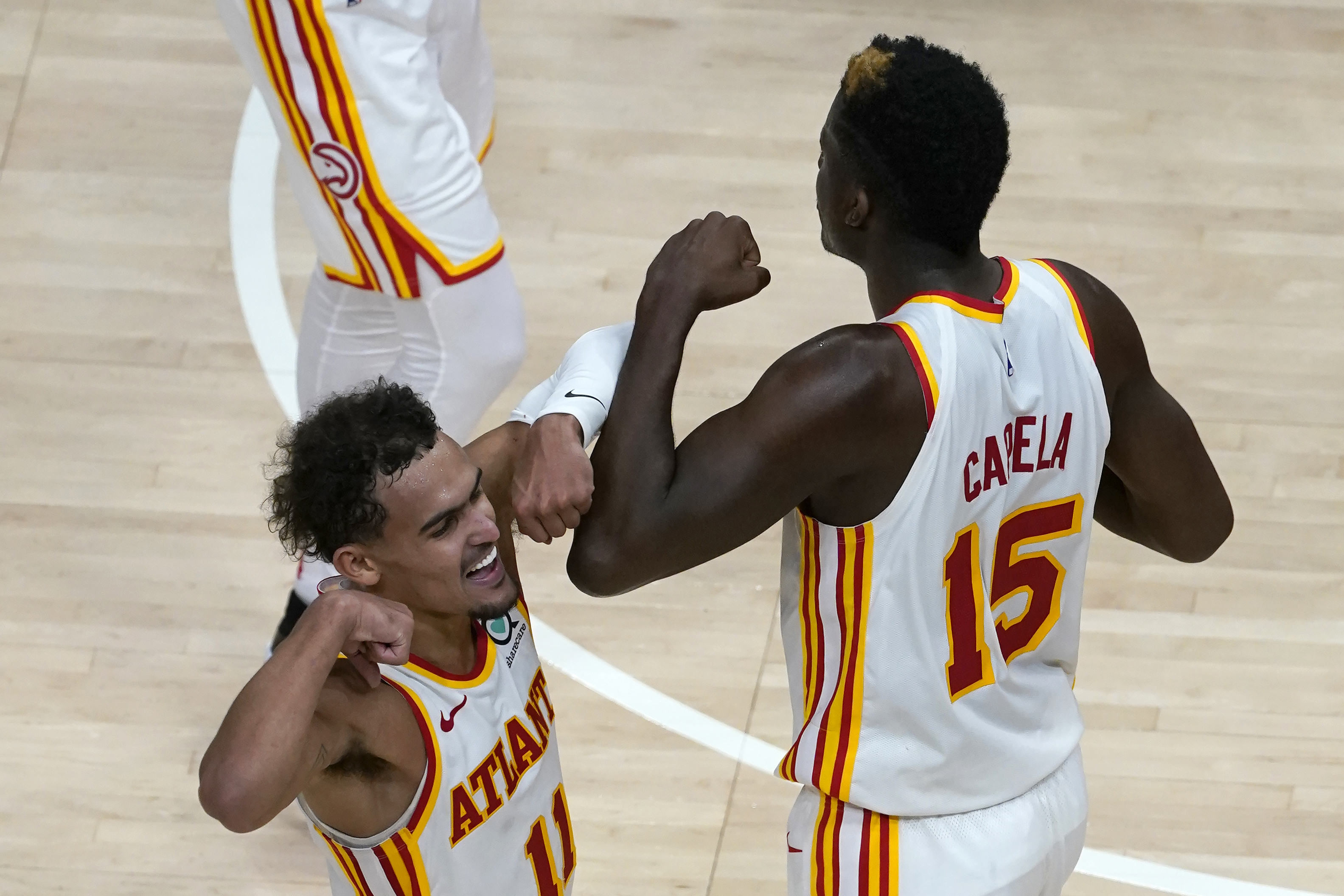 Atlanta Hawks guard Trae Young (11) and center Clint Capela (15) celebrate a basket in overtime of the team's 123-115 victory over the Detroit Pistons in an NBA basketball game Wednesday, Jan. 20, 2021, in Atlanta. (AP Photo/John Bazemore)