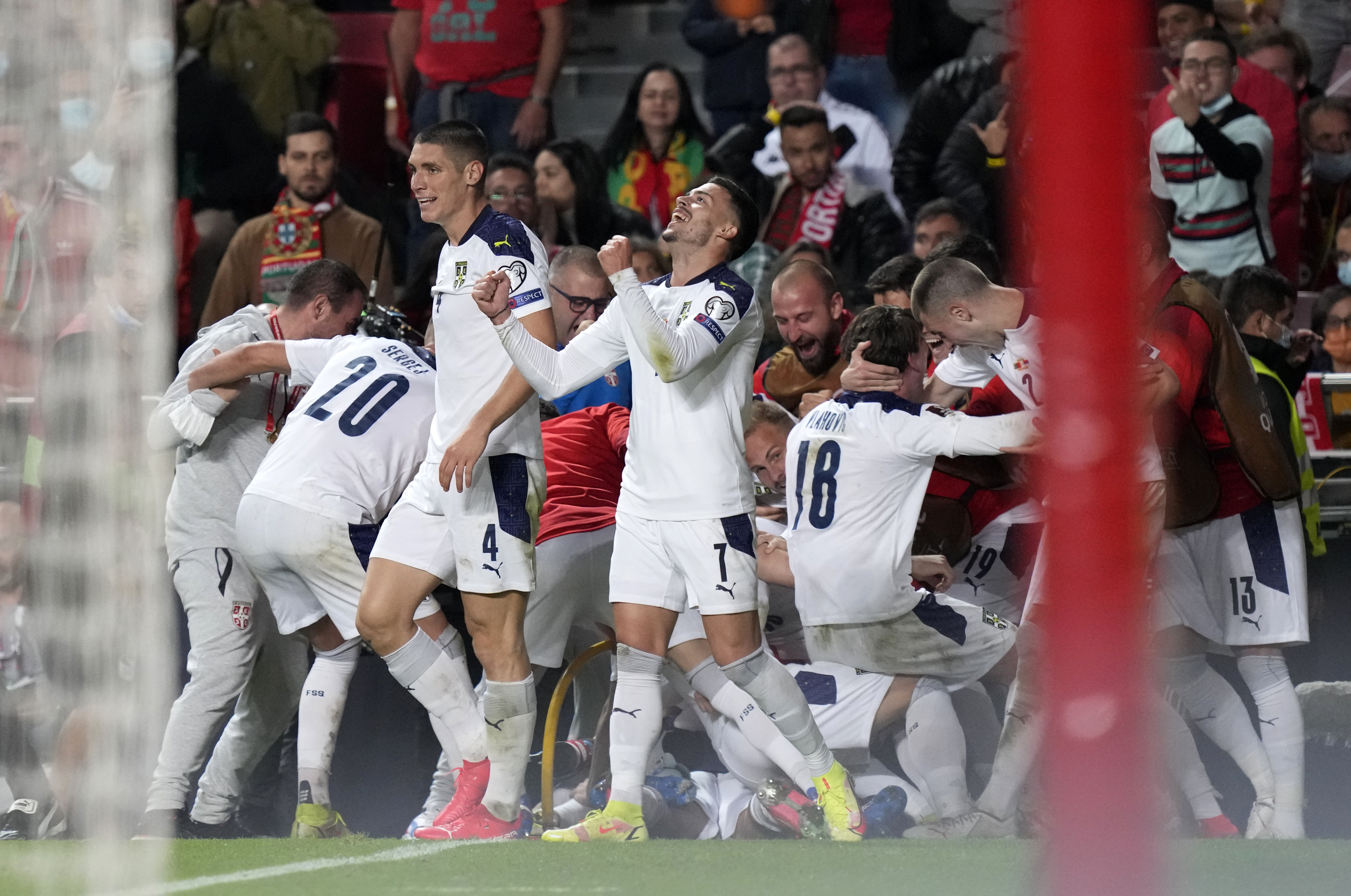 Serbia's Aleksandar Mitrovic celebrates with teammates after scoring his side's second goal during the World Cup 2022 group A qualifying soccer match between Portugal and Serbia at the Luz stadium in Lisbon, Sunday, Nov 14, 2021. (AP Photo/Armando Franca)