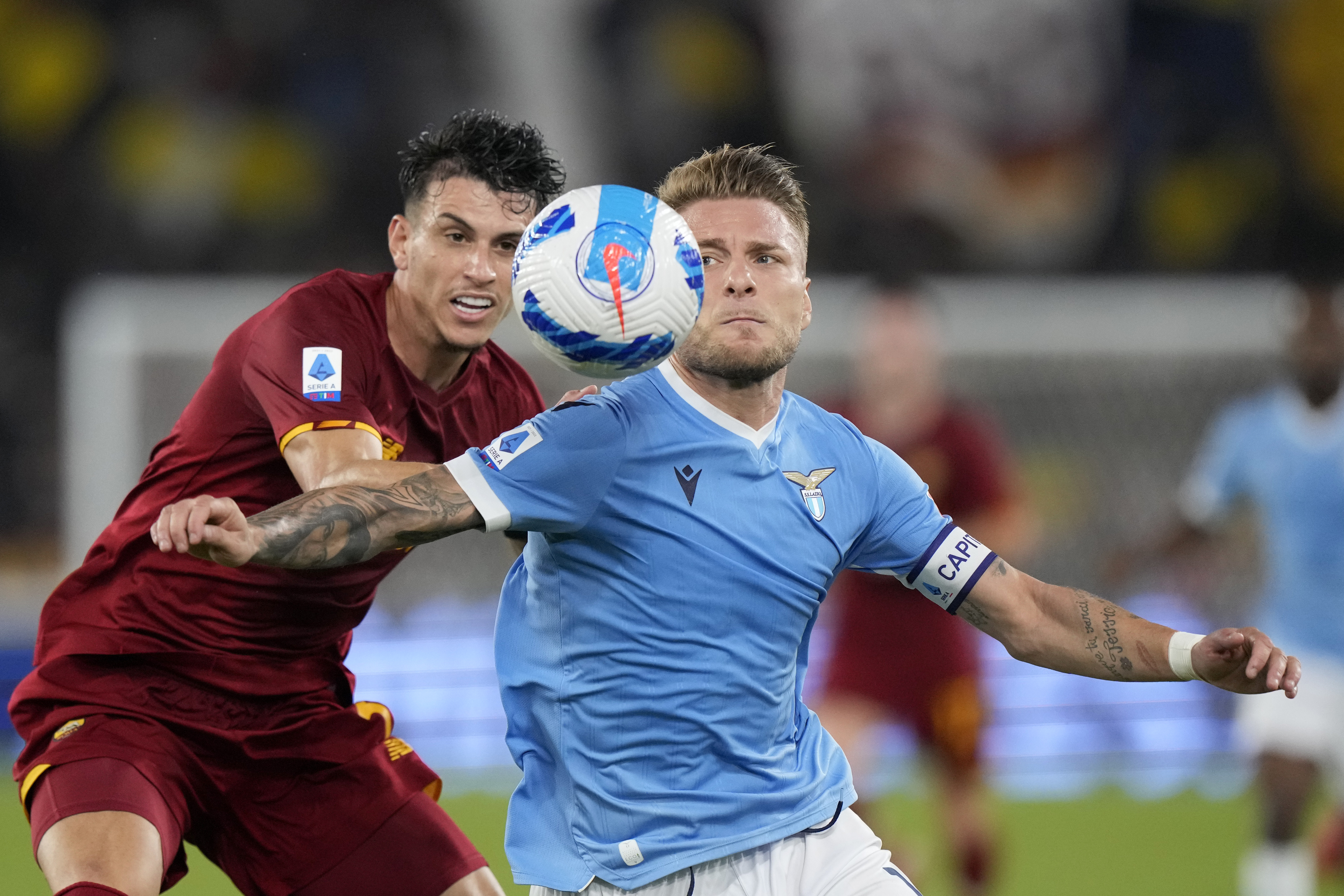 Lazio's Ciro Immobile shields the ball from Roma's Roger Ibanez, left, during a Serie A soccer match between Lazio and Roma, at Rome's Olympic Stadium, Sunday, Sept. 26, 2021. (AP Photo/Andrew Medichini)