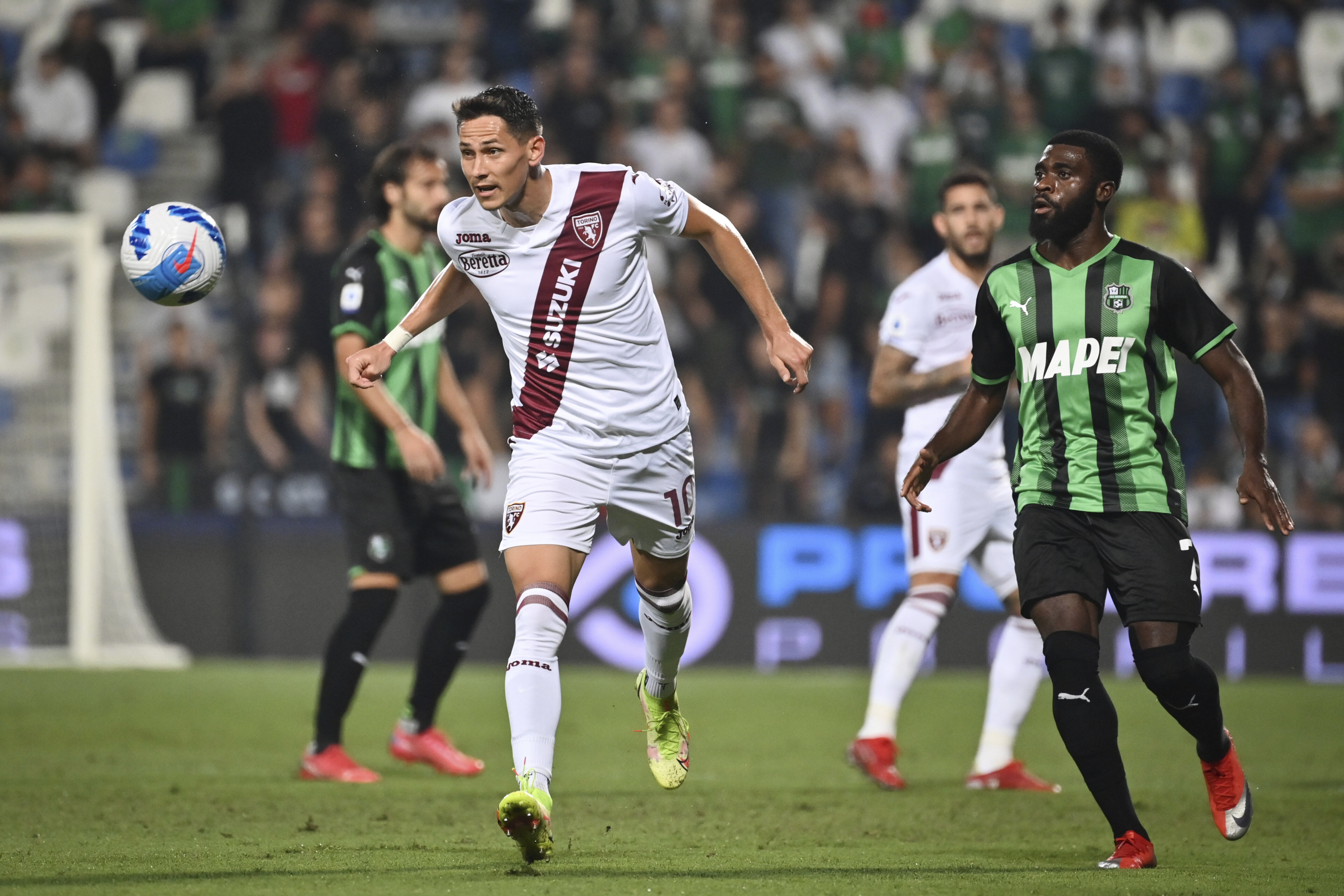 Sassuolo's Jeremie Boga, right, competes for the ball with Torino's Sasa Lukic during the Serie A soccer match between Sassuolo and Torino, at the Mapei stadium in Reggio Emilia, Italy, Friday, Sept. 17, 2021. (Massimo Paolone/LaPresse via AP)