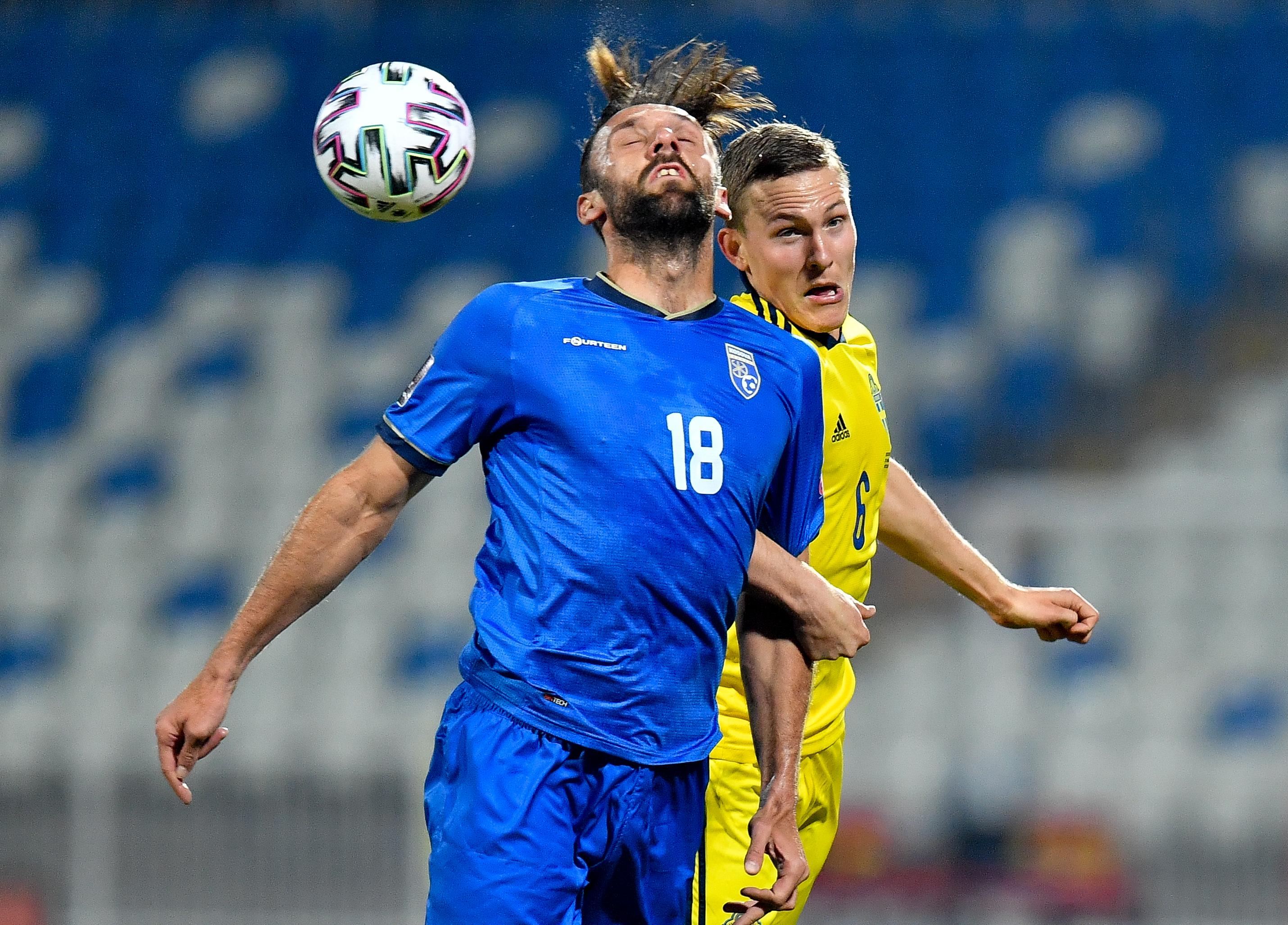 epa09103699 Vedat Muriqi (L) of Kosovo in action against Ludwig Augustinsson of Sweden during the FIFA World Cup 2022 qualifying soccer match between Kosovo and Sweden in Pristina, Kosovo, 28 March 2021.  EPA-EFE/GEORGI LICOVSKI