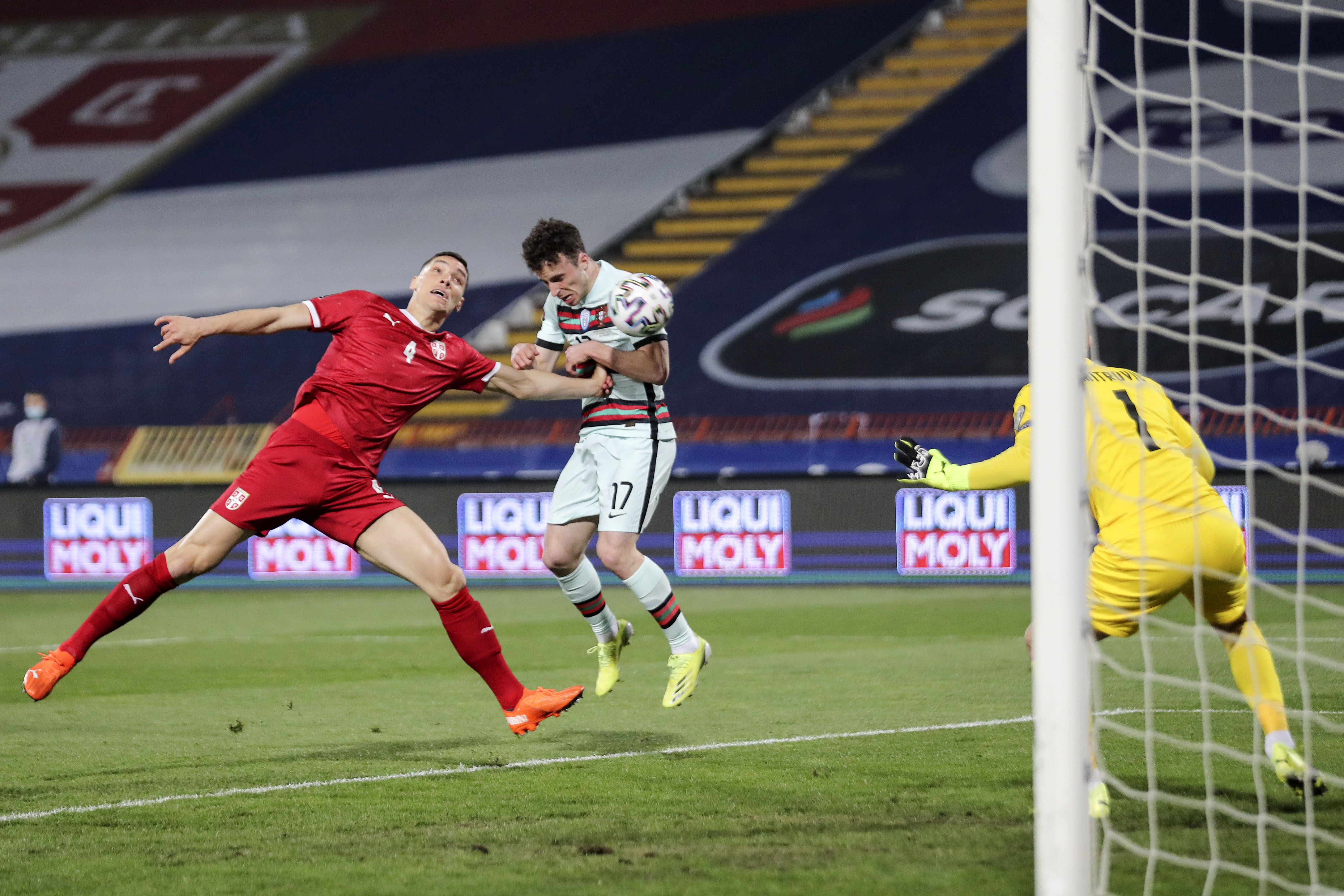 epa09101966 Serbia's Nikola Milenkovic (L) figths for the ball with Portugal's Diogo Jota (C) during the Group A of FIFA World Cup Qatar 2022 qualifier match at Rajko Mitic Stadium in Belgrade, Serbia, 27th March 2021.  EPA-EFE/MIGUEL A. LOPES