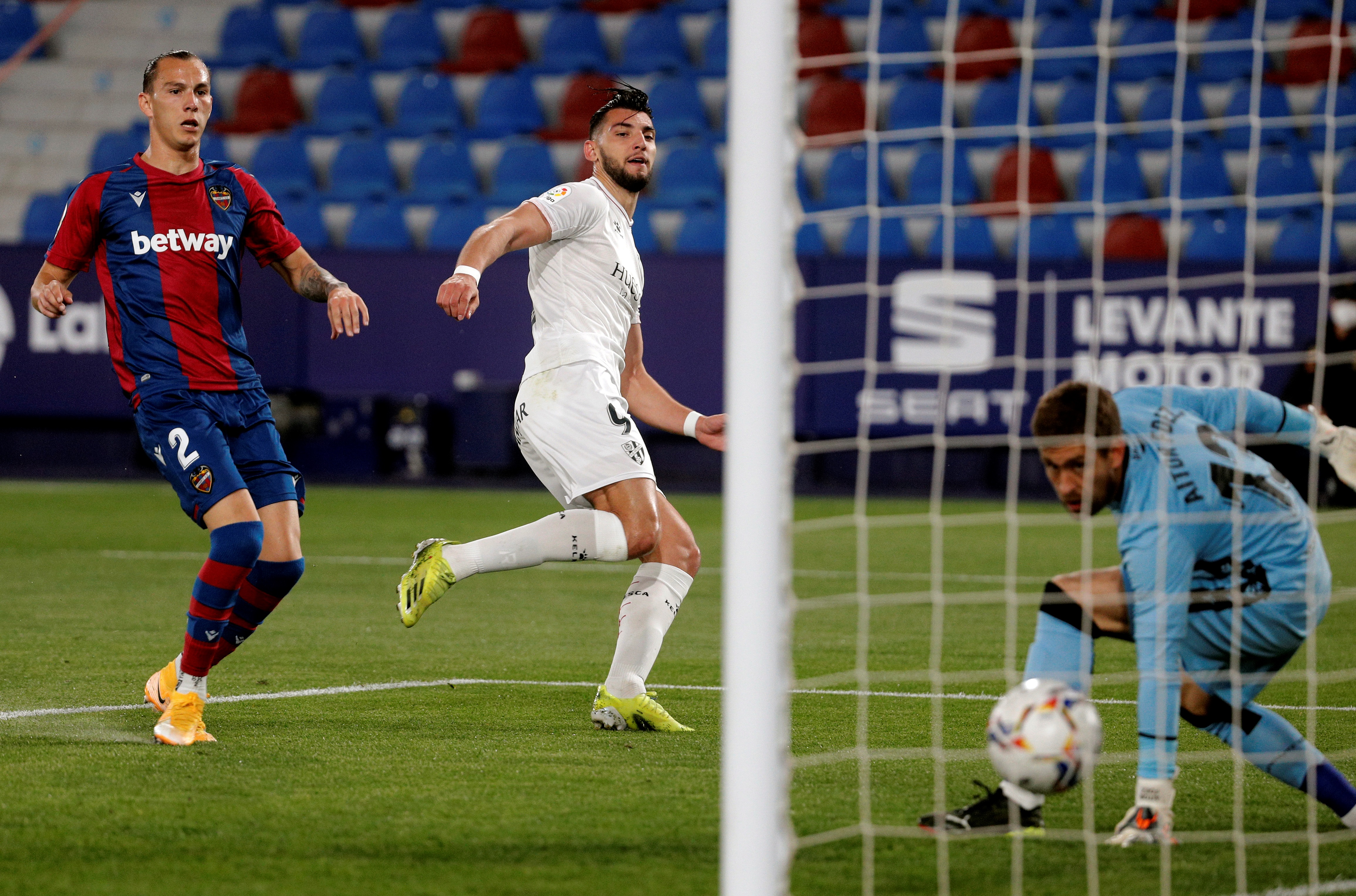 epa09112422 Huesca's striker Rafa Mir (C) scores the 0-1 lead during the Spanish LaLiga soccer match between Levante UD and SD Huesca at Ciudad de Valencia stadium in Valencia, eastern Spain, 02 April 2021.  EPA-EFE/Juan Carlos Cardenas