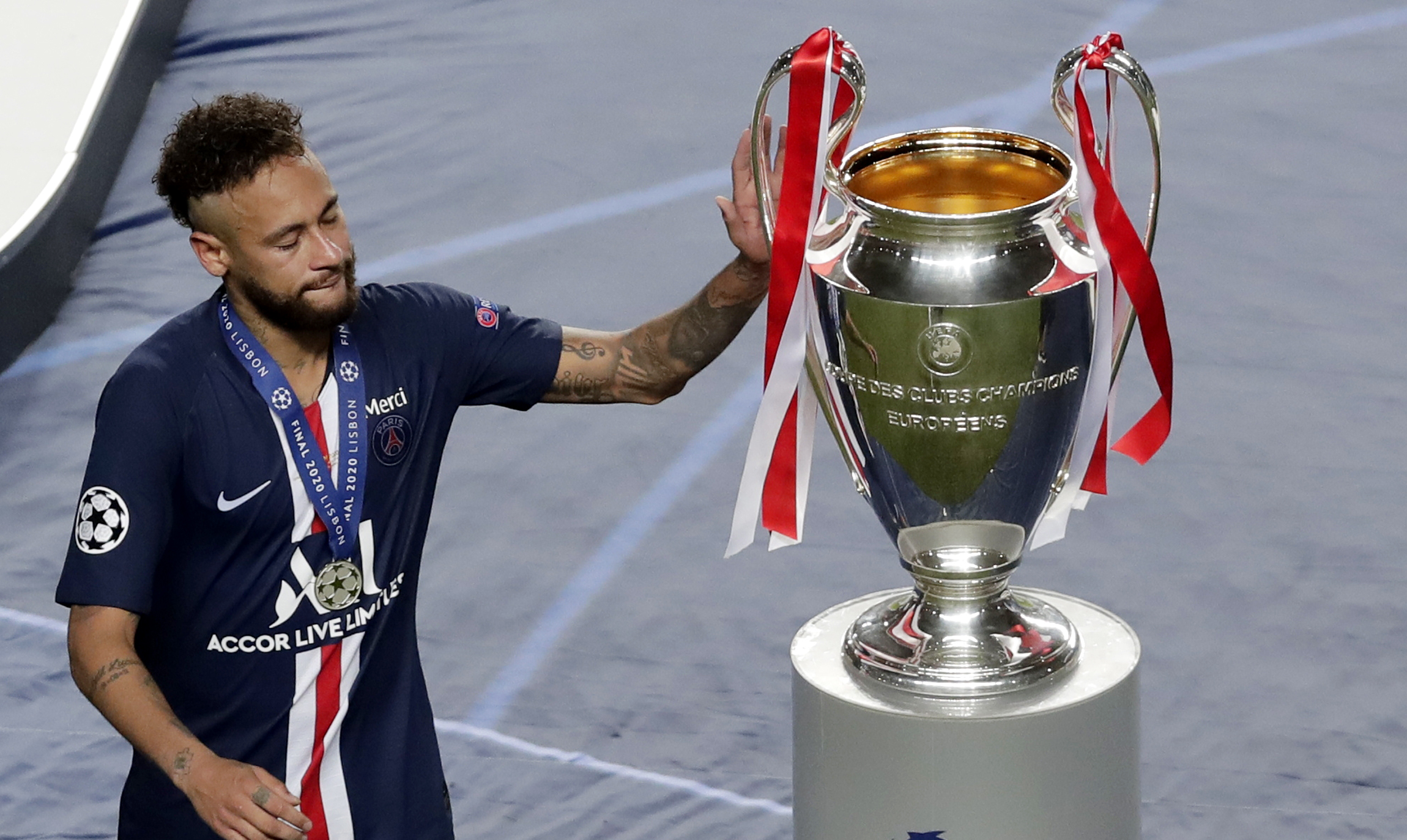 epa08620908 Neymar of PSG touches the trophy after receiving his runner-up medal after the UEFA Champions League final between Paris Saint-Germain and Bayern Munich in Lisbon, Portugal, 23 August 2020. PSG lost 0-1.  EPA-EFE/Manu Fernandez / POOL