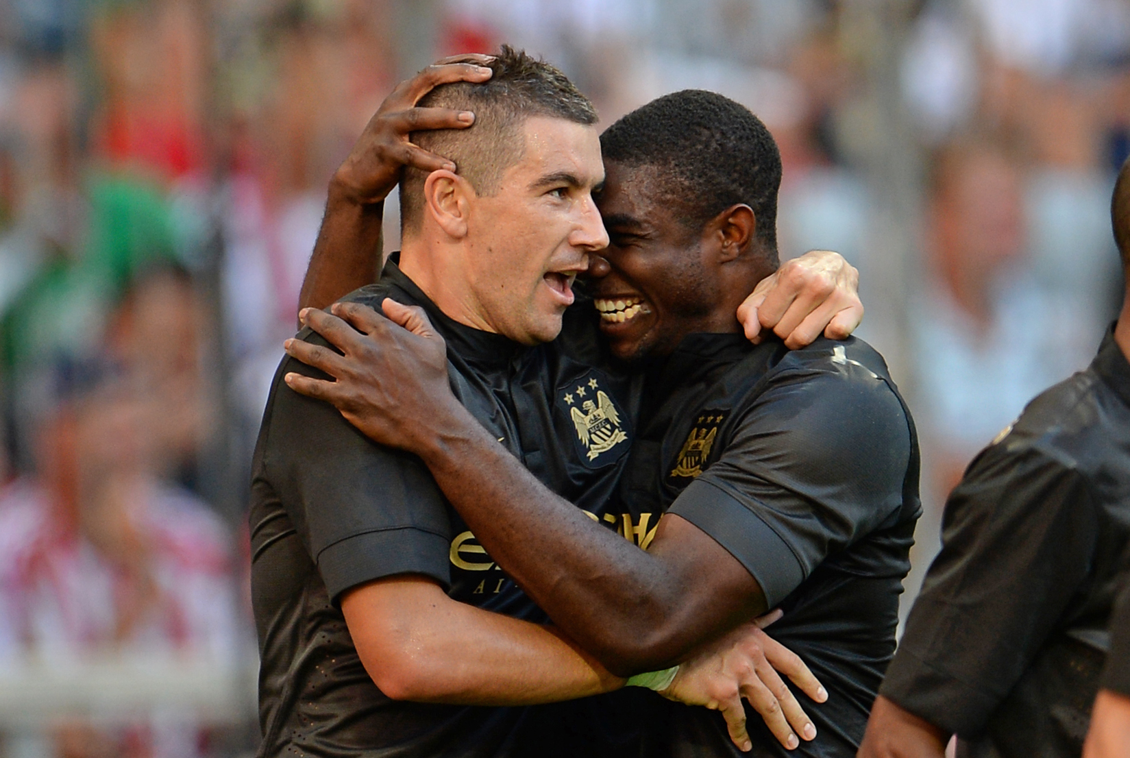 epa03808847 Manchester's Aleksandar Kolarov (L) celebrates with teammate Micah Richards after scoring the 3-0 during the Audi Cup soccer semifinal match Manchester City vs AC Milan at Allianz Arena in Munich, Germany, 31 July 2013.  EPA/Andreas Gebert