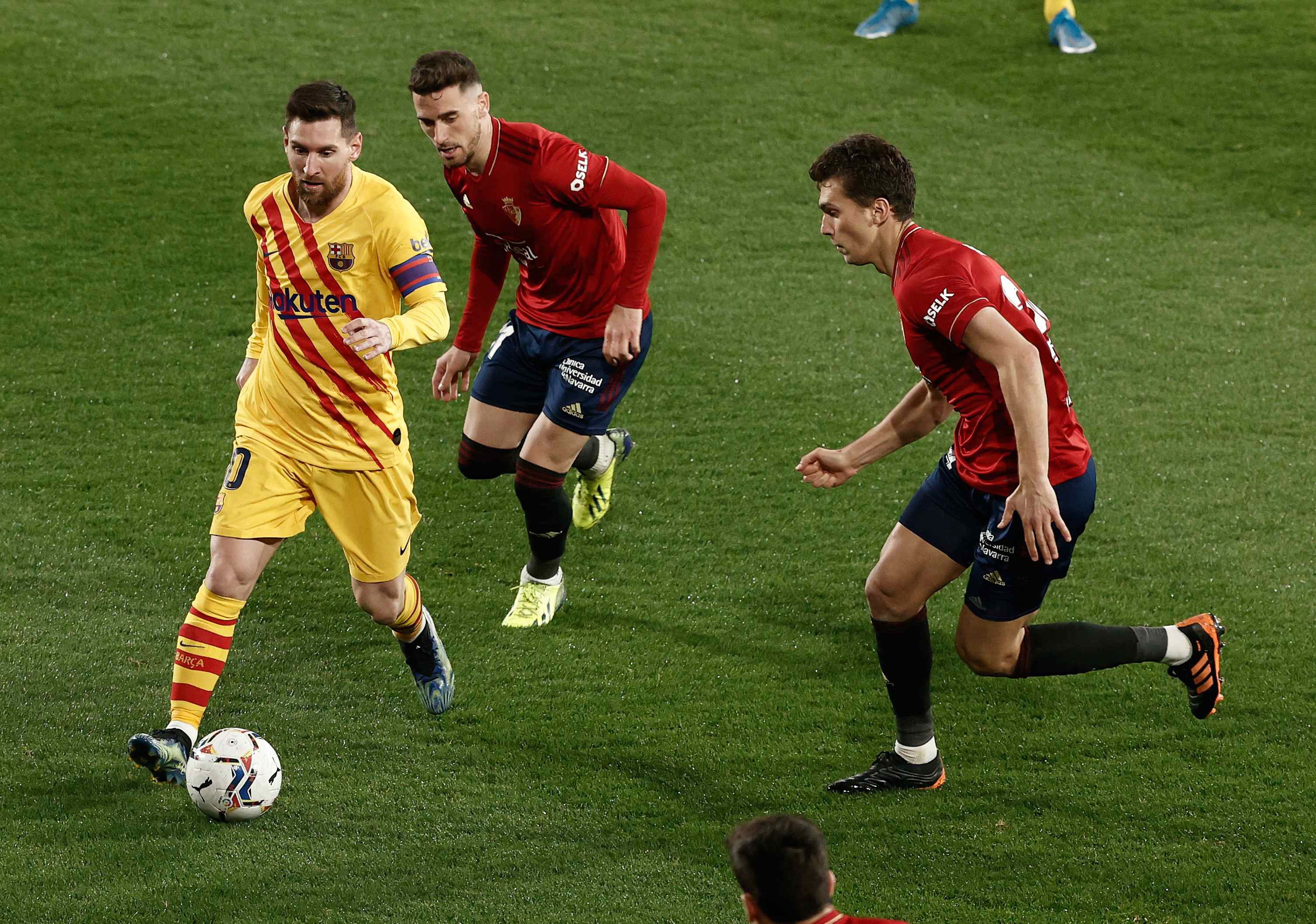 epa09058001 Barcelona's Lionel Messi (L) in action during the Spanish La Liga soccer match between CA Osasuna and FC Barcelona at El Sadar stadium in Pamplona, Spain, 06 March 2021.  EPA-EFE/Jesus Diges