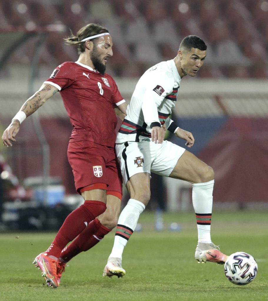 epa09101947 Portugal?s Cristiano Ronaldo (R) in action against Serbia?s Nemanja Gudelj (L) during the FIFA World Cup 2022 qualifying soccer match between Serbia and Portugal in Belgrade, Serbia, 27 March 2021.  EPA-EFE/Andrej Cukic