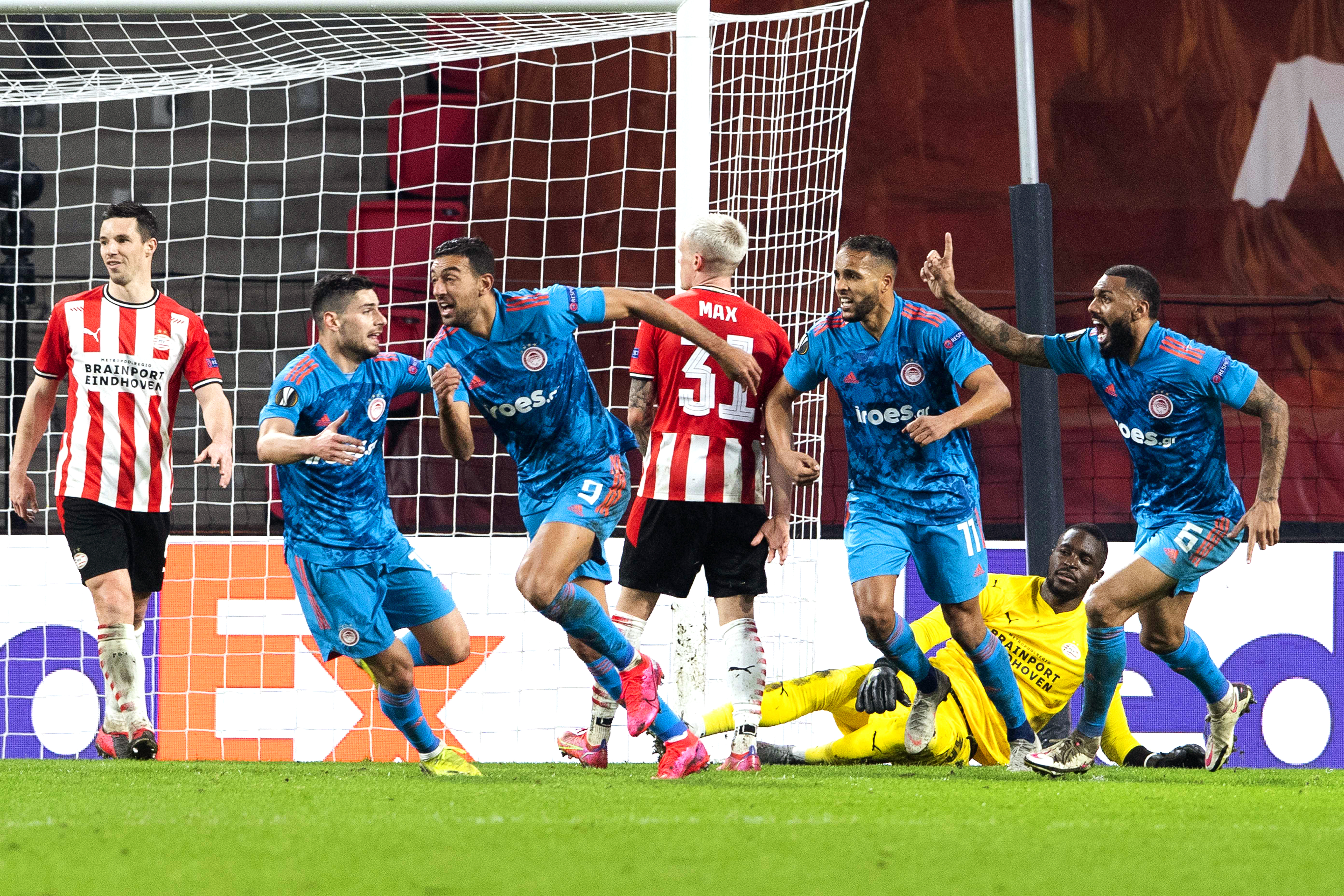 epa09037079 Players of Olympiacos celebrate their first goal during the UEFA Europa League round of 32, second leg soccer match between PSV Eindhoven and Olympiacos Piraeus in Eindhoven, Netherlands, 25 February 2021.  EPA-EFE/Olaf Kraak