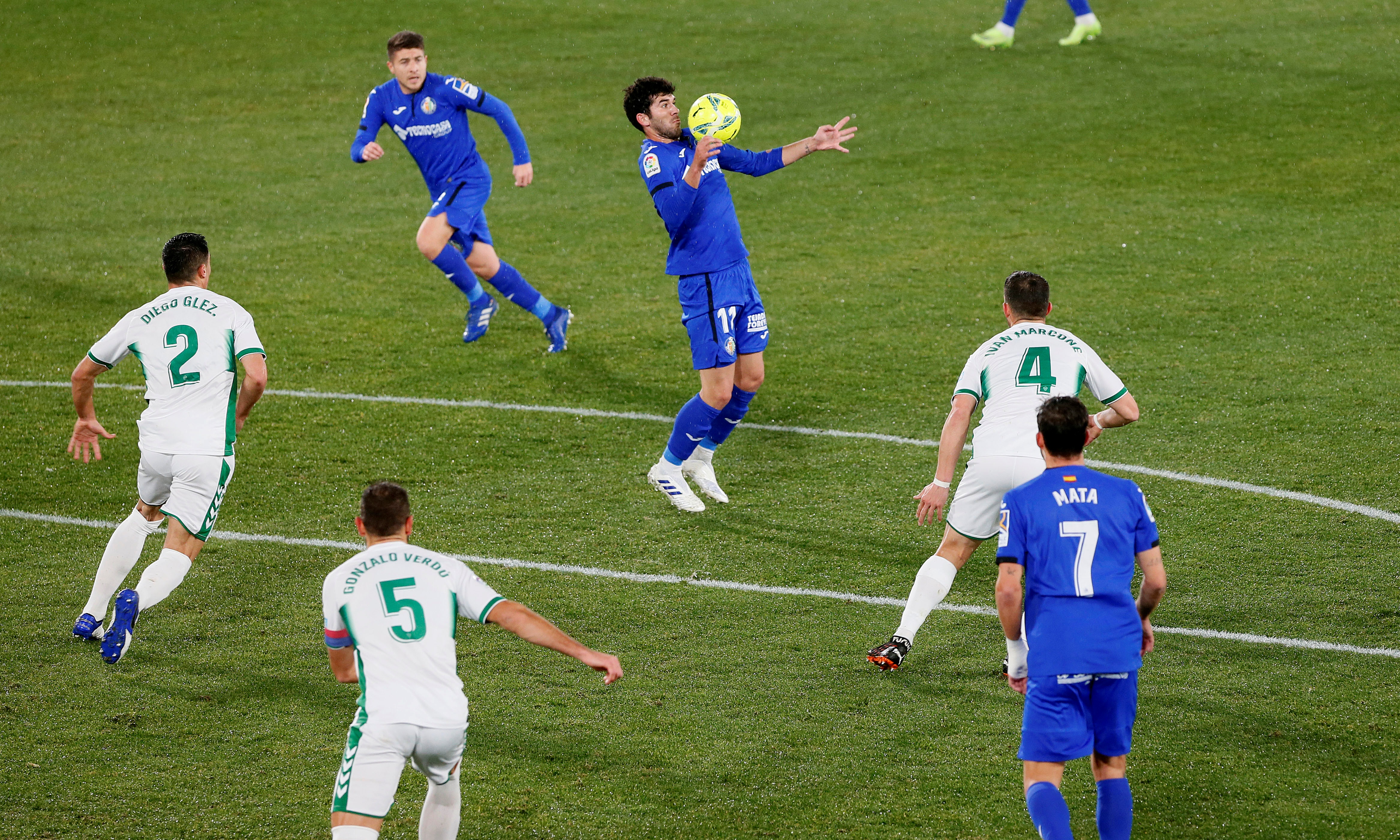 epa08931997 Getafe's Carles Alena (C) in action during the Spanish LaLiga soccer match between Elche CF and Getafe at Martin Valero stadium in Elche, eastern Spain, 11 January 2021.  EPA-EFE/Ramon