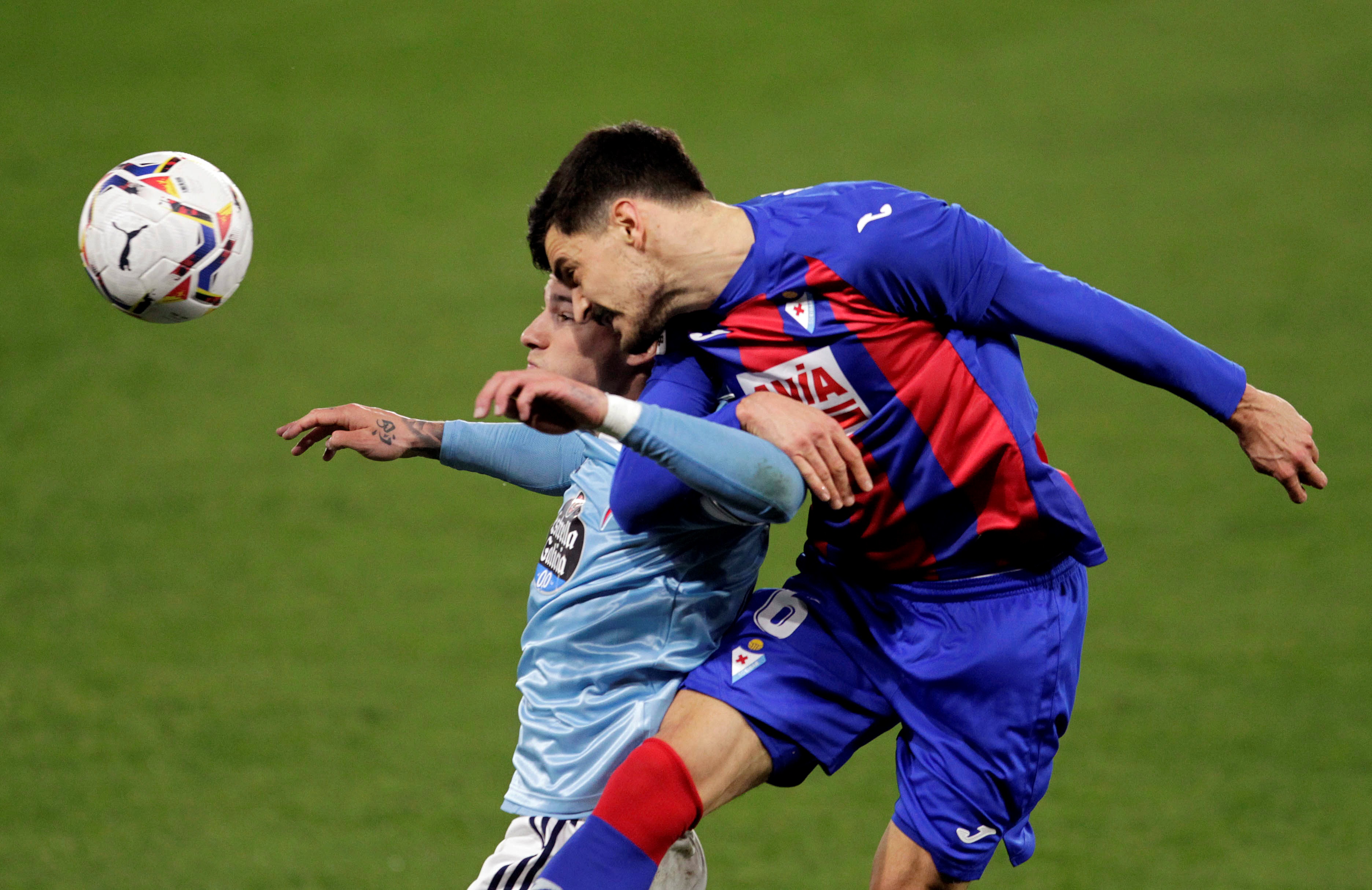 epa08962915 Celta's striker Santi Mina (L) duels for the ball against Eibar's midfielder Sergio Alvarez (R) during the Spanish LaLiga soccer match between Celta de Vigo and SD Eibar at Balaidos stadium in Vigo, nothwest Spain, 24 January 2021.