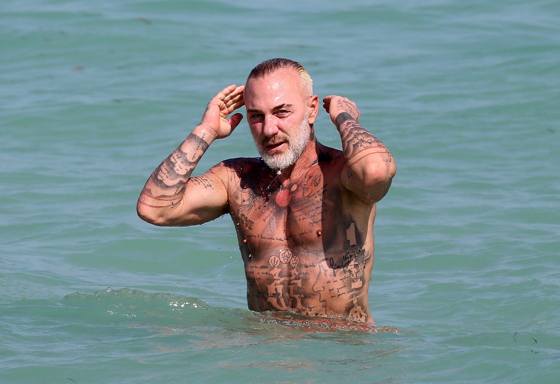 EXCLUSIVE: Italian DJ Gianluca Vacchi shows off his tattoos in a tiny speedo on the beach in Miami