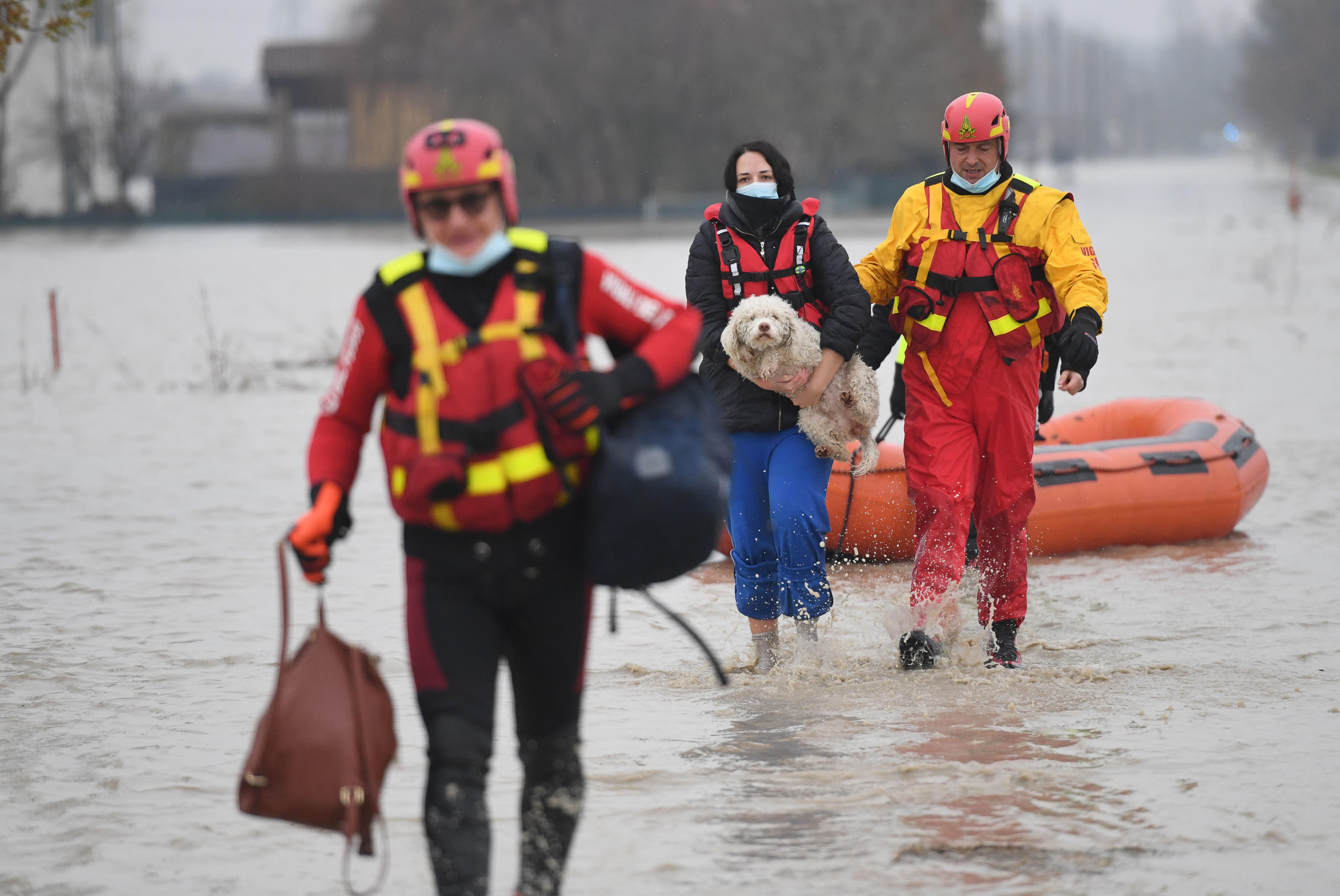 epa08866141 A family is evacuated following the breaking of the embankment of the Panaro river, in the hamlet of Gaggio, in Piano Castelfranco municipality, Italy, 06 December 2020.  EPA-EFE/ELISABETTA BARACCHI