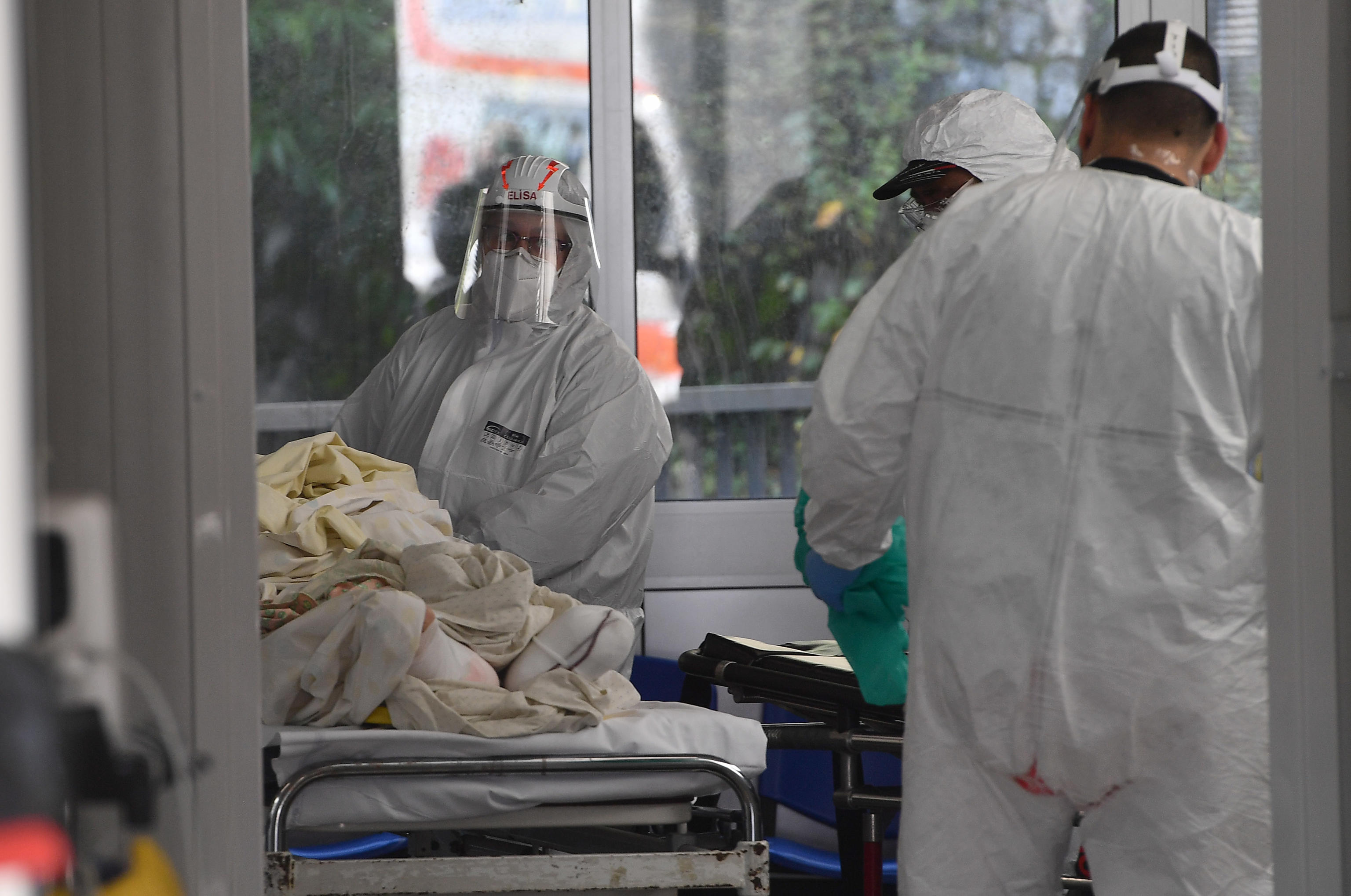 epa08809652 Health workers in protective equipment work in front of the respiratory triage prepared for suspected Covid-19 patients mounted in front of the emergency room of the San Martino polyclinic, Genoa, Italy, 09 November 2020.  EPA-EFE/LUCA ZENNARO