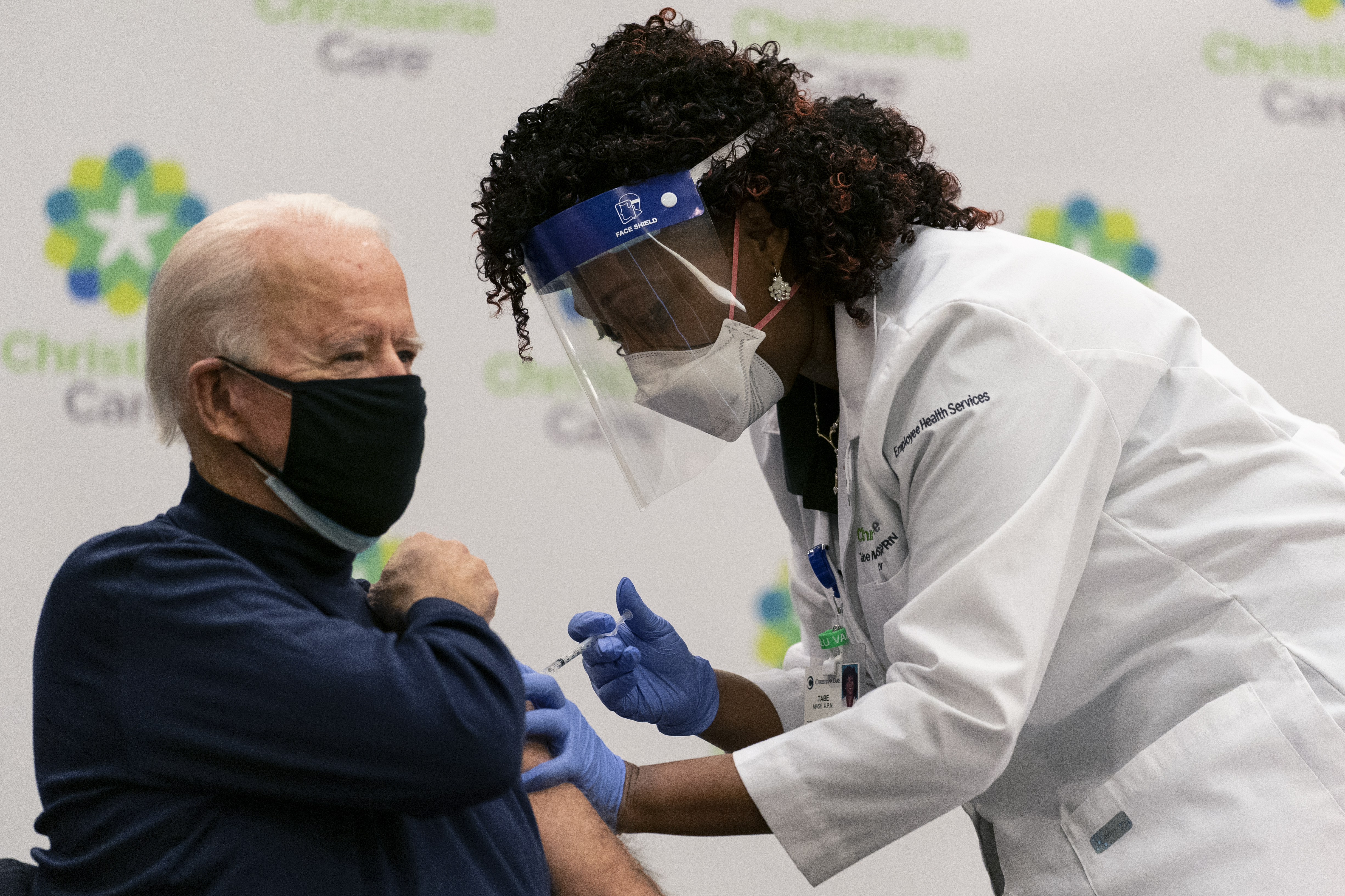 President-elect Joe Biden receives his first dose of the coronavirus vaccine from Nurse partitioner Tabe Mase at Christiana Hospital in Newark Del., Monday, Dec. 21, 2020, from nurse practitioner Tabe Mase. (AP Photo/Carolyn Kaster)