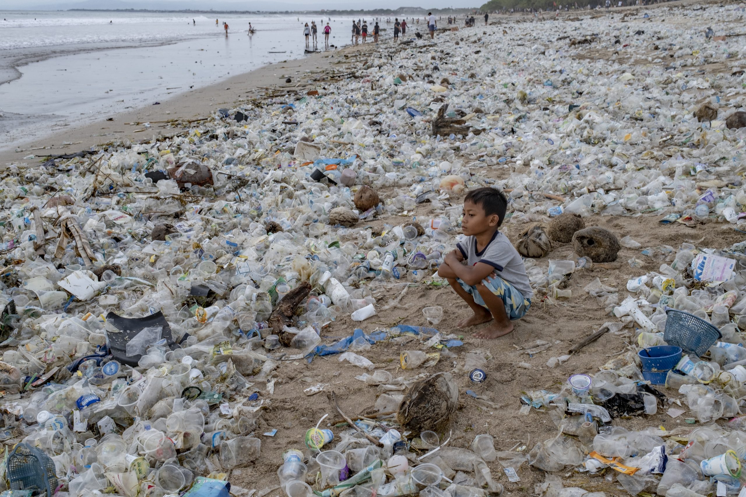 epa08912370 A boy sits on beach covered in plastic wastes at Kuta Beach in Bali, Indonesia, 31 December 2020.  EPA-EFE/MADE NAGI