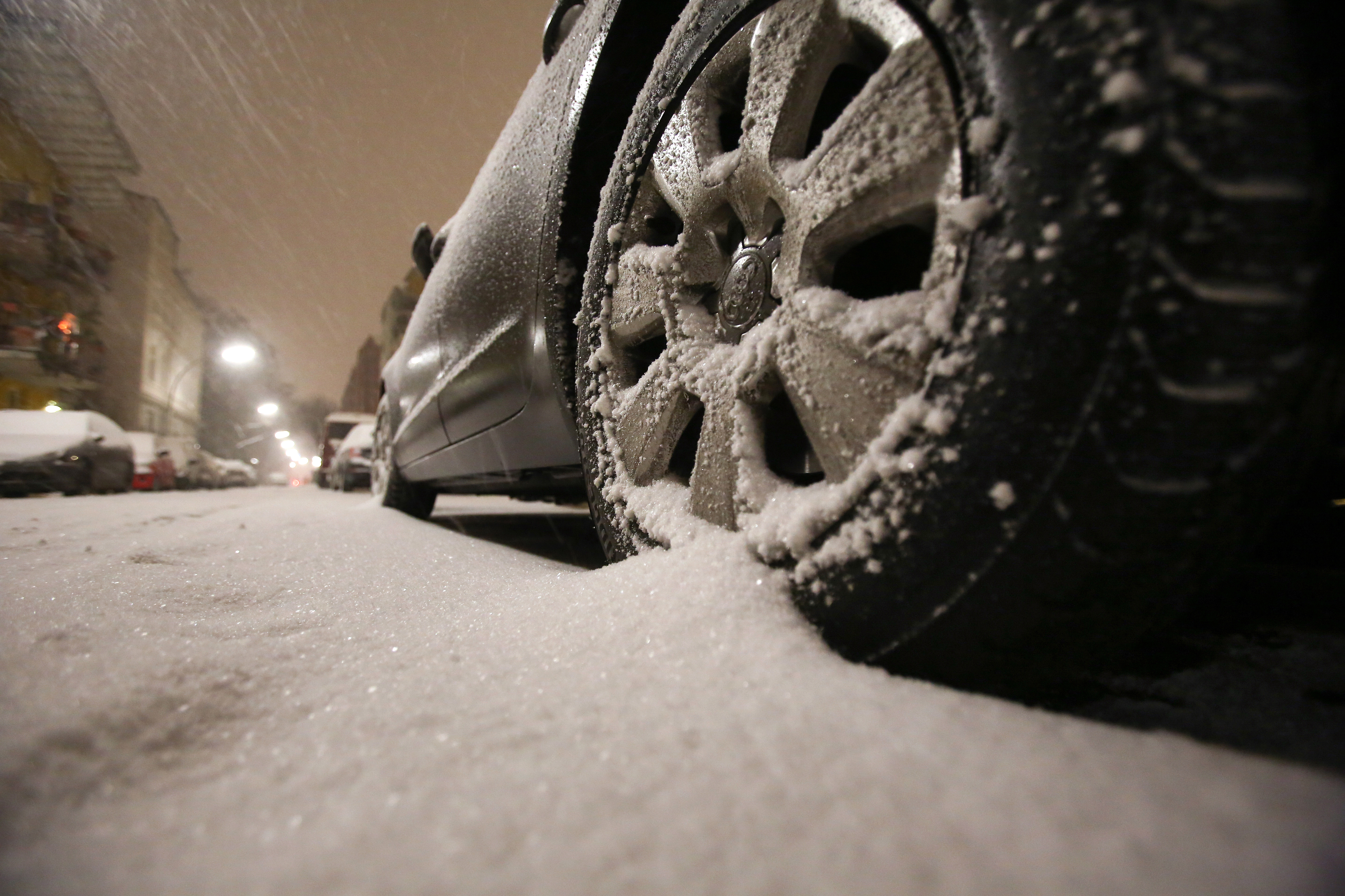 epa05092257 The tire of a car is seen in a thin layer of snow in a residential area in Hamburg, Germany, after the North of the country was hit by a cold front with snowfalls overnight 08 January 2016.  EPA/BODO MARKS