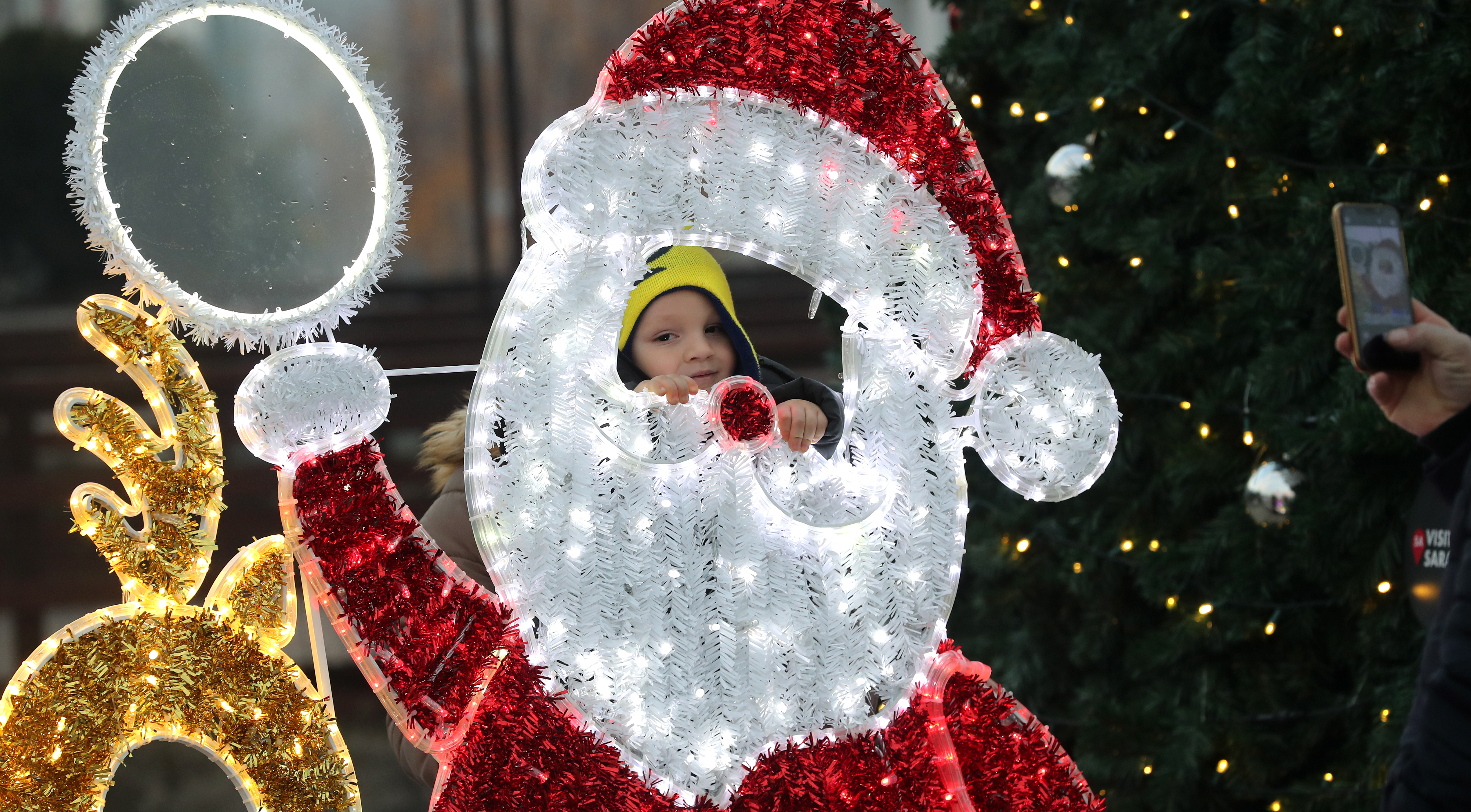 epa08887946 The boy poses next to the decorations of Santa Claus for the New Year 2021 and the Christmas holidays in the center of Sarajevo, Bosnia and Herzegovina, 16 December 2020.  EPA-EFE/FEHIM DEMIR