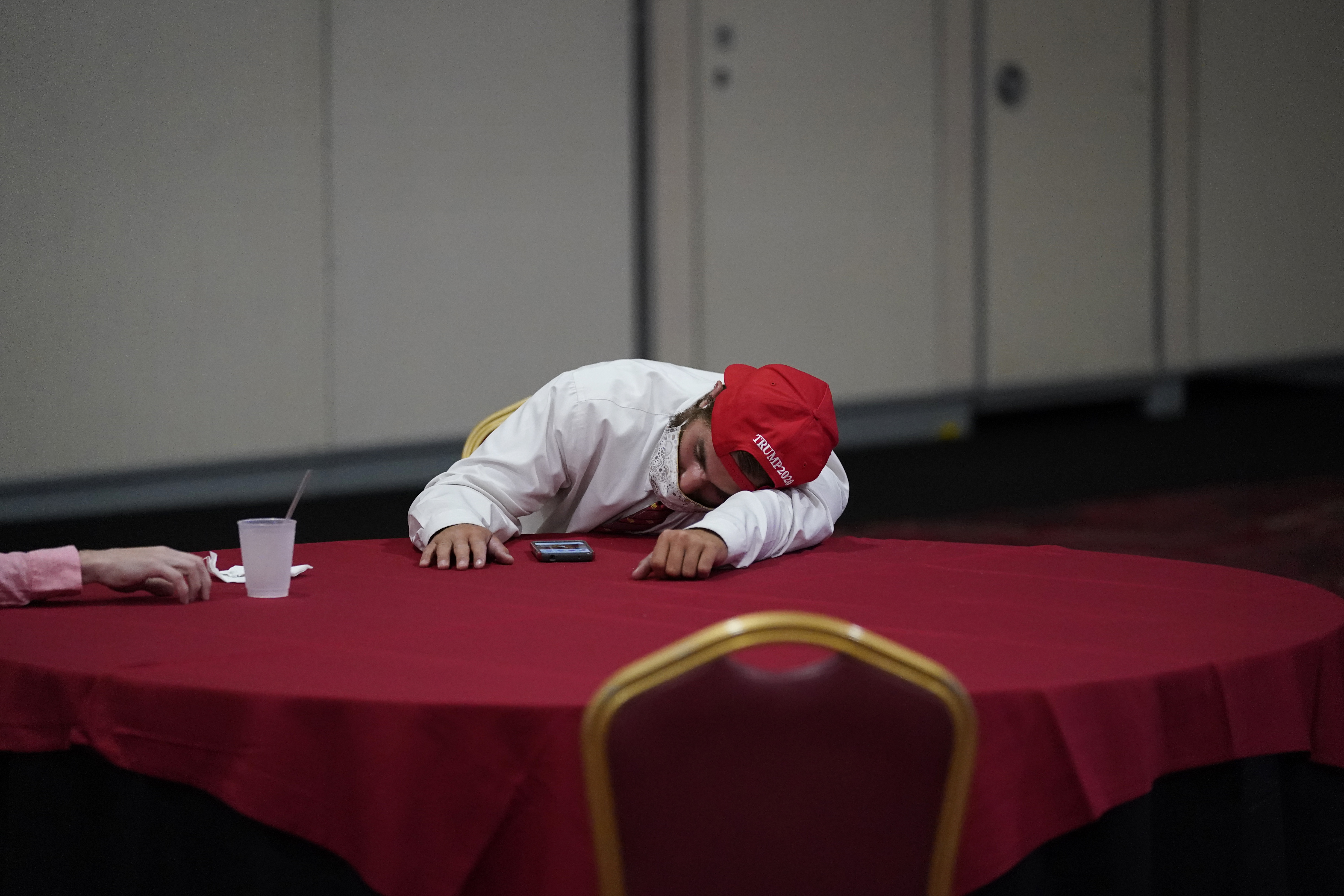 A supporter of President Donald Trump rests on a table while waiting for election results at an election night party, Tuesday, Nov. 3, 2020, in Las Vegas. (AP Photo/John Locher)