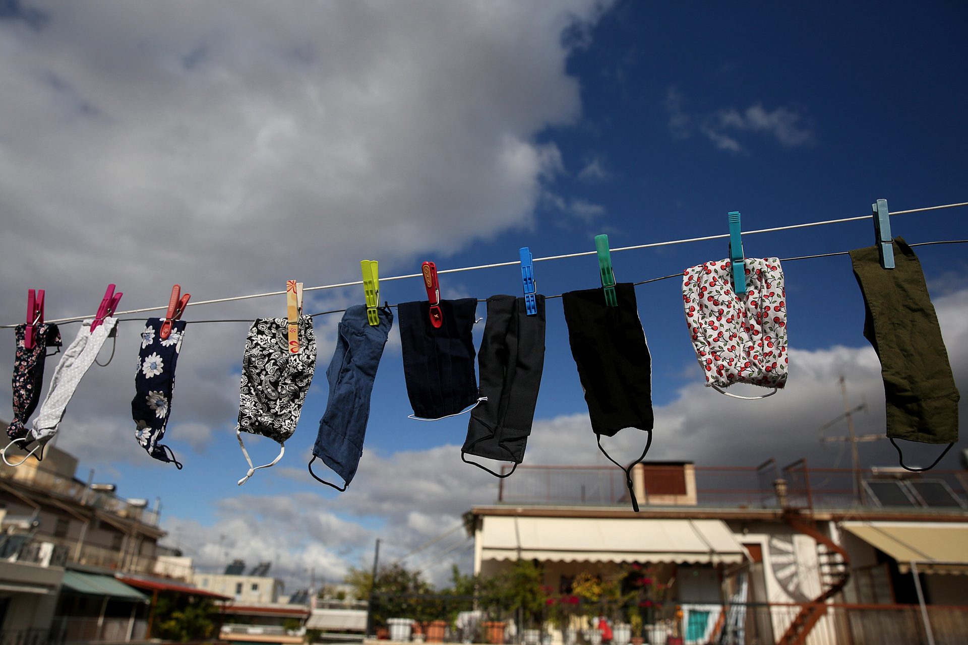 epa08807129 Face masks hang to dry from a rope between terraces in Athens, Greece, 08 November 2020. New restrictions have been enforced in Athens amid a second wave of COVID-19 infections sweeping through Europe.  EPA-EFE/ORESTIS PANAGIOTOU