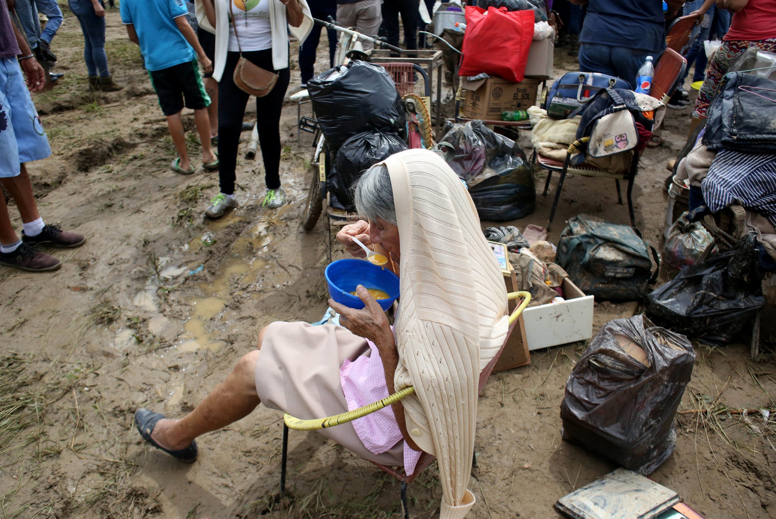 A woman eats a meal after her home was flooded when heavy rains caused the river Carapo to overflow in Rubio, Venezuela, November 8, 2020. REUTERS/Carlos Eduardo Ramirez