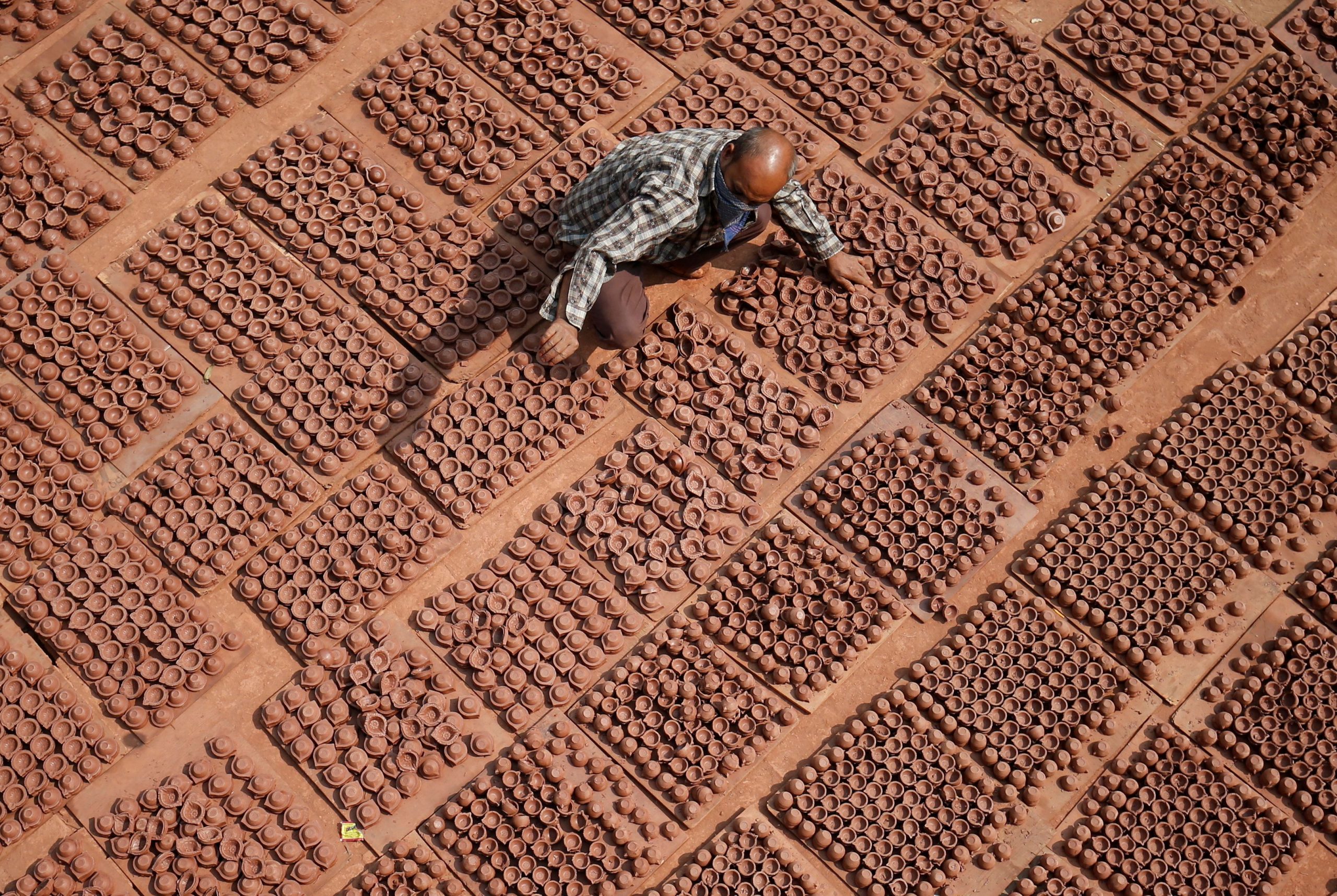 A potter arranges earthen lamps, which are used to decorate homes and temples during Diwali, the Hindu festival of lights, at a workshop in Ahmedabad, India November 9, 2020. REUTERS/Amit Dave     TPX IMAGES OF THE DAY