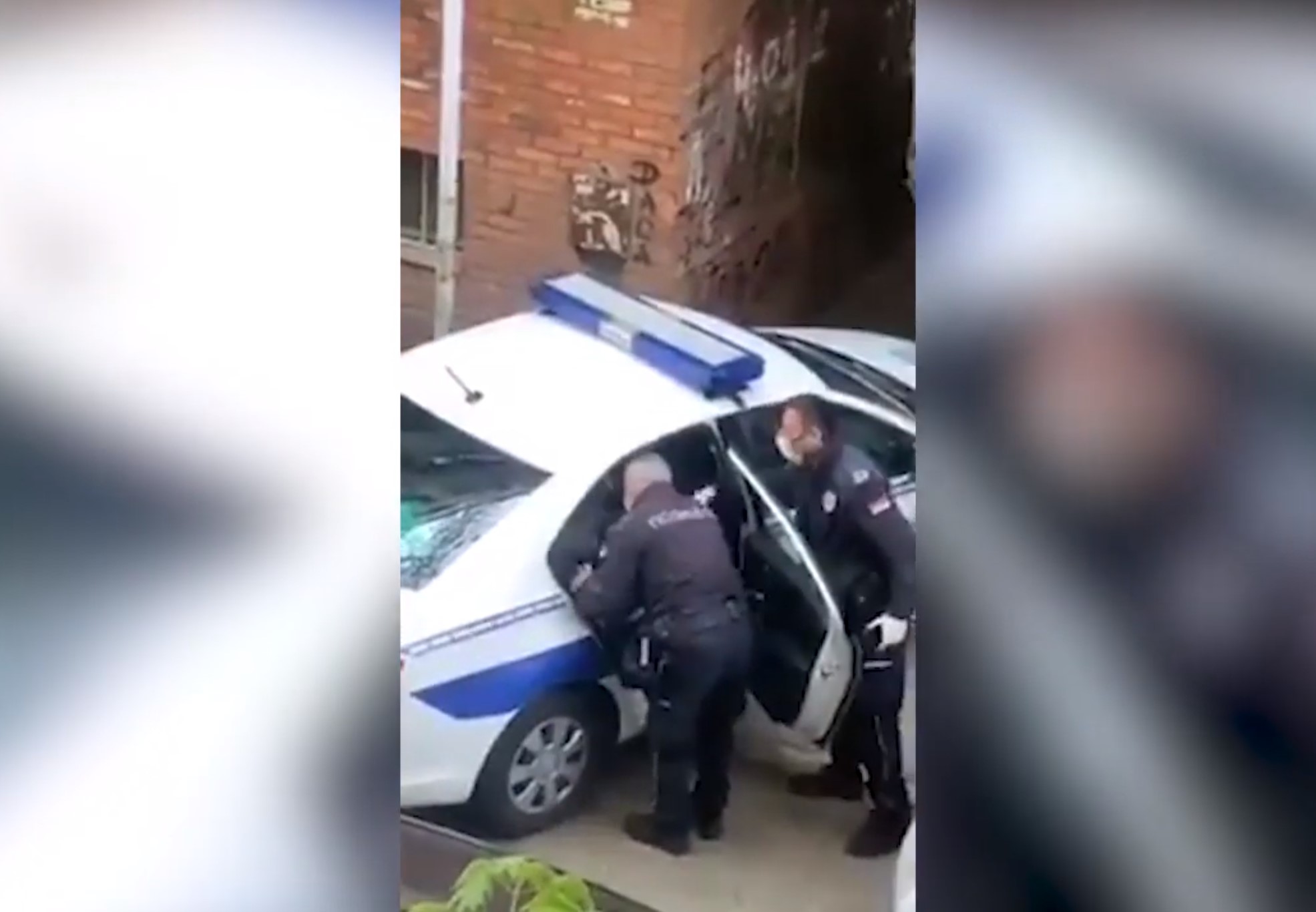 policajac šamara mladića koji se nalazi na zadnjem sedištu policijskog automobila