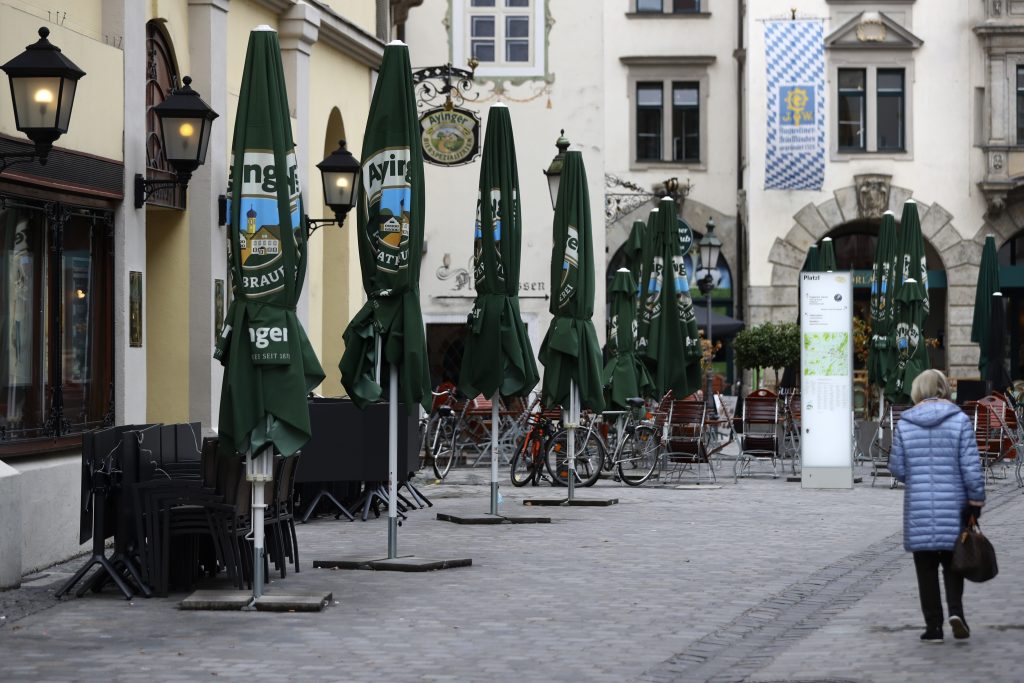A woman passes stacked chairs and tables at the famous restaurant 'Hofbraeuhaus' downtown in Munich, Germany, Monday, Nov. 2, 2020. A one month long partial lockdown becomes effective in Germany on Monday. (AP Photo/Matthias Schrader)