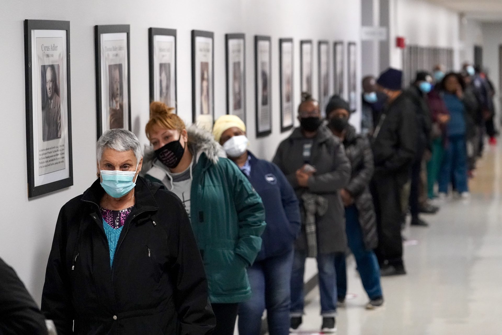 People line up to vote at a polling place inside the Bartow Community Center, Tuesday, Nov. 3, 2020, in the Bronx borough of New York. (AP Photo/Mark Lennihan)
