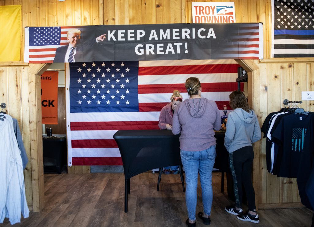 Patrons of the "Trumptana" popup store in Manhattan, Mont., check out with President Donald Trump's campaign apparel on Tuesday, Nov. 3, 2020. (AP Photo/Tommy Martino)