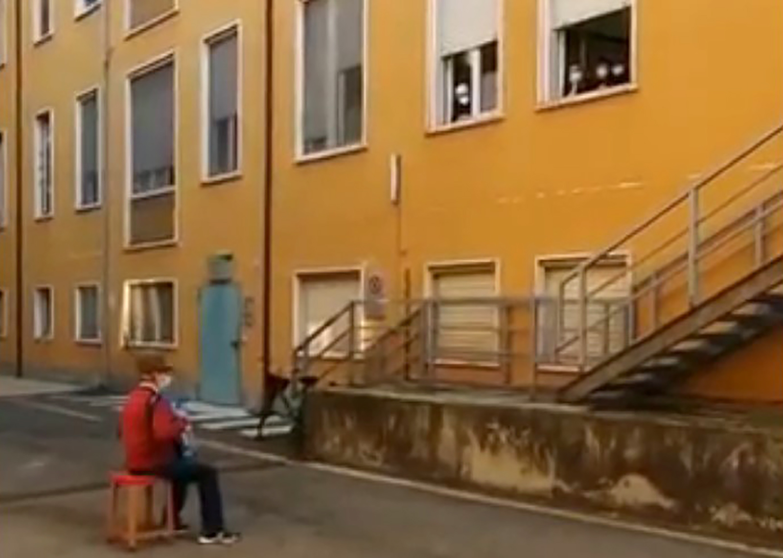 Dekica svira bolesnoj zeni ispred bolnice