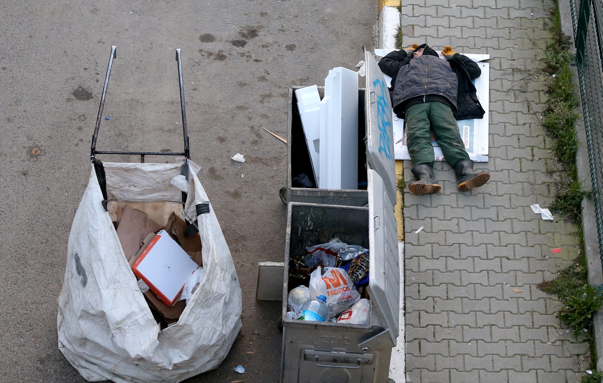 epa06487168 A waste collector sleeps beside the garbage dumpsters the in Istanbul, Turkey, 31 January 2018.  EPA-EFE/ERDEM SAHIN