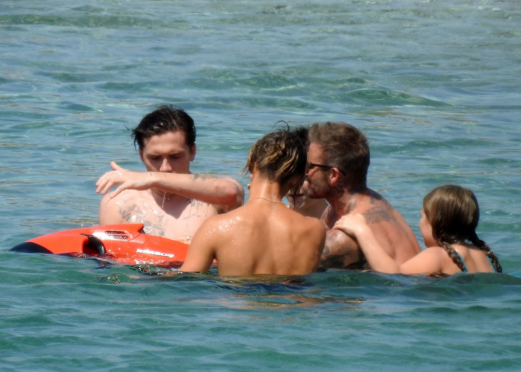 *PREMIUM EXCLUSIVE* David Beckham hugs daughter Harper, 9, as he takes a dip in a pair of Versace swim shorts on his Greek vacation.