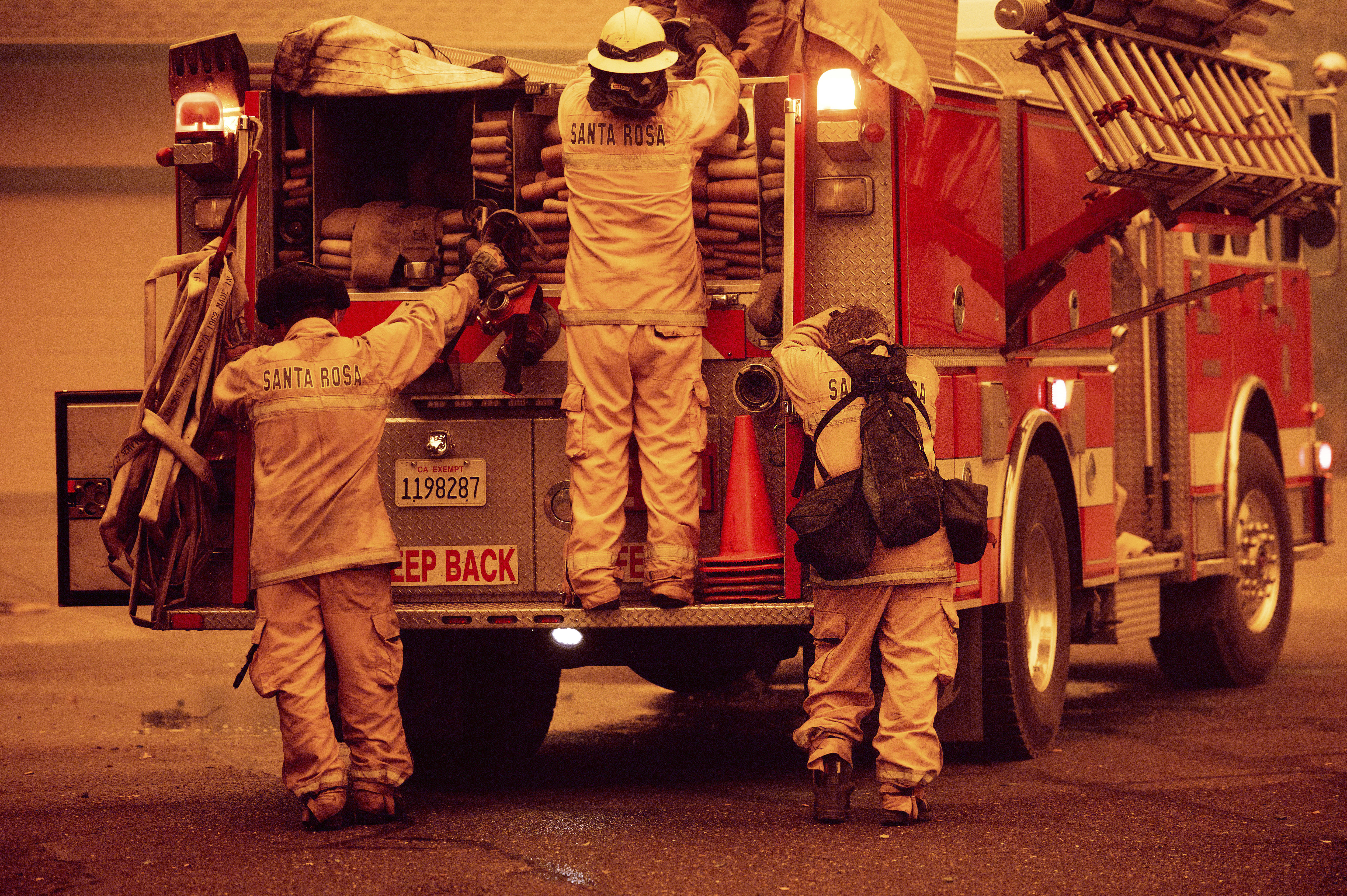 A firefighter rests his head against an engine after a night spent battling the Glass Fire in Santa Rosa, Calif., on Monday, Sept. 28, 2020. (AP Photo/Noah Berger)