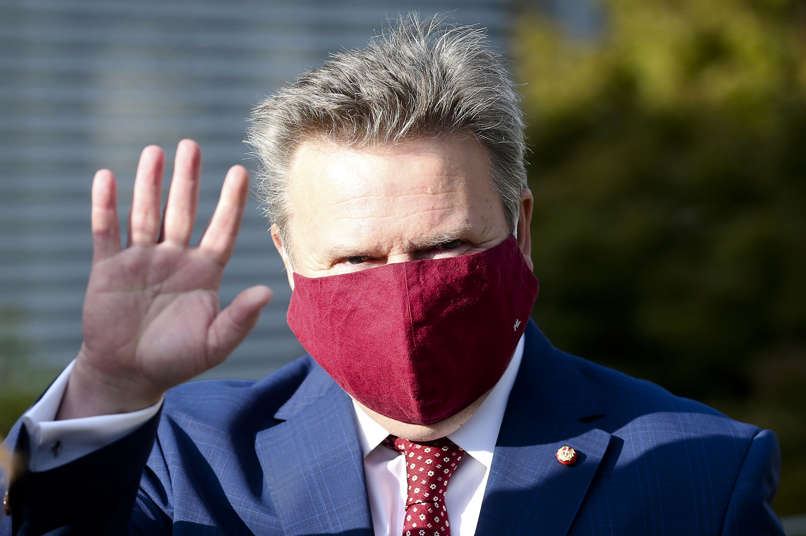 Vienna Mayor Michael Ludwig with face mask from the Social Democrats, SPOE, waves before entering a polling station to the local elections in Vienna, Austria, Sunday, Oct. 11, 2020. (AP Photo/Ronald Zak)