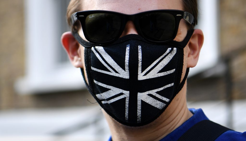 epa08441835 A man wears a Union Flag face mask in London, Britain, 24 May 2020. Countries around the world are taking increased measures to stem the widespread of the SARS-CoV-2 coronavirus which causes the Covid-19 disease.  EPA-EFE/ANDY RAIN