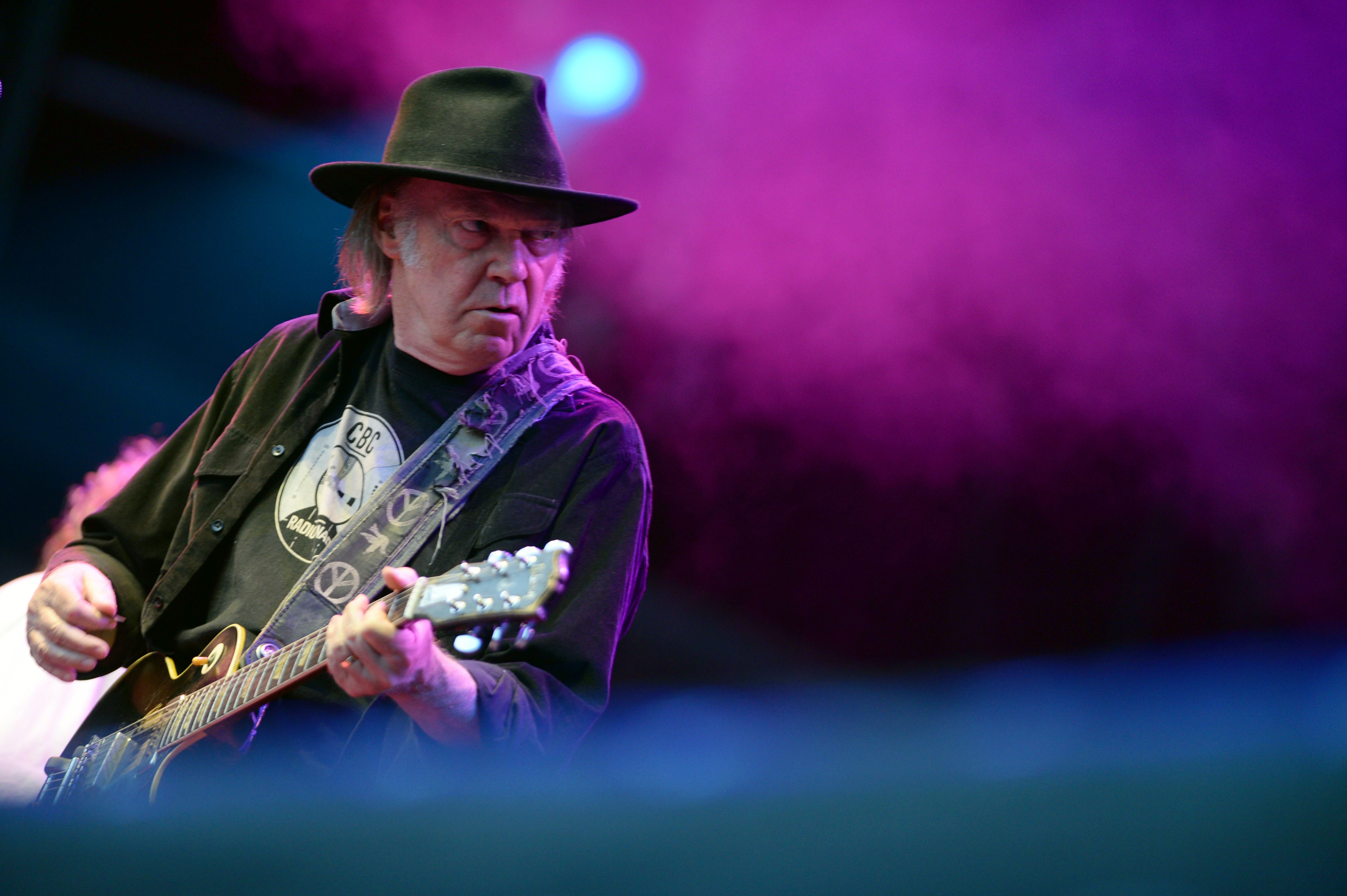 epa03788317 Canadian musician Neil Young performs on stage during his concert at the Moon and Stars Festival on the Piazza Graden in Locarno, Switzerland, 14 July 2013.  EPA/SAMUEL GOLAY